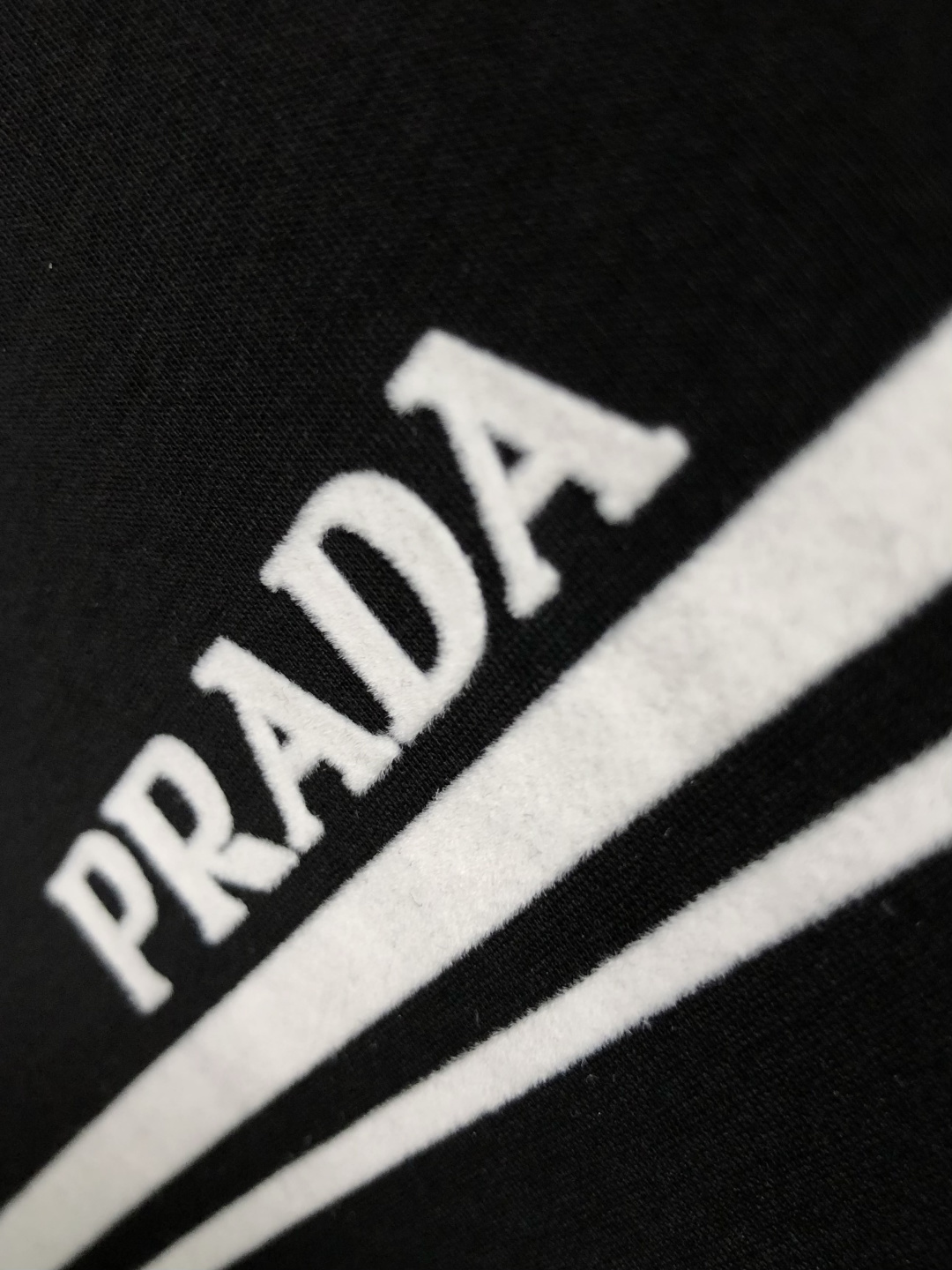 Prad*正码正拍M-xxxl2026春夏短袖，以黑白撞色为主调，巧妙融入植绒线条印花金属三角标元素，打
