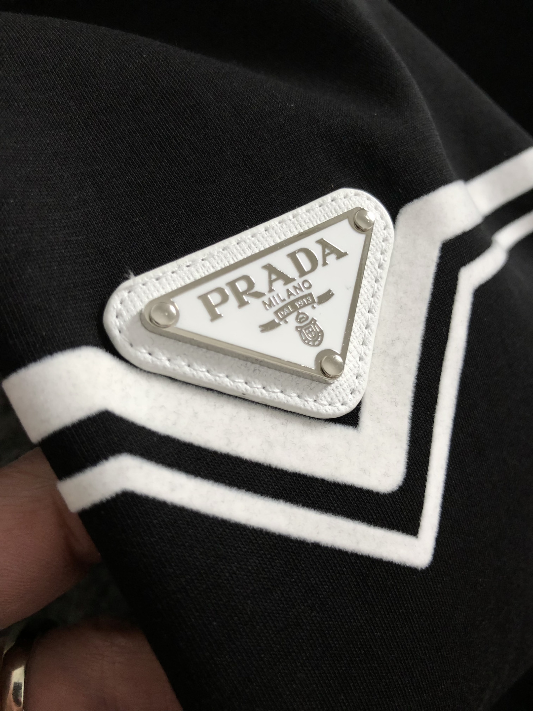 Prad*正码正拍M-xxxl2026春夏短袖，以黑白撞色为主调，巧妙融入植绒线条印花金属三角标元素，打