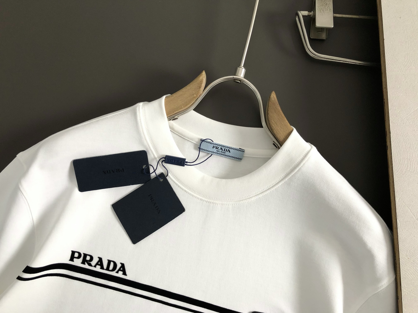 Prad*正码正拍M-xxxl2026春夏短袖，以黑白撞色为主调，巧妙融入植绒线条印花金属三角标元素，打