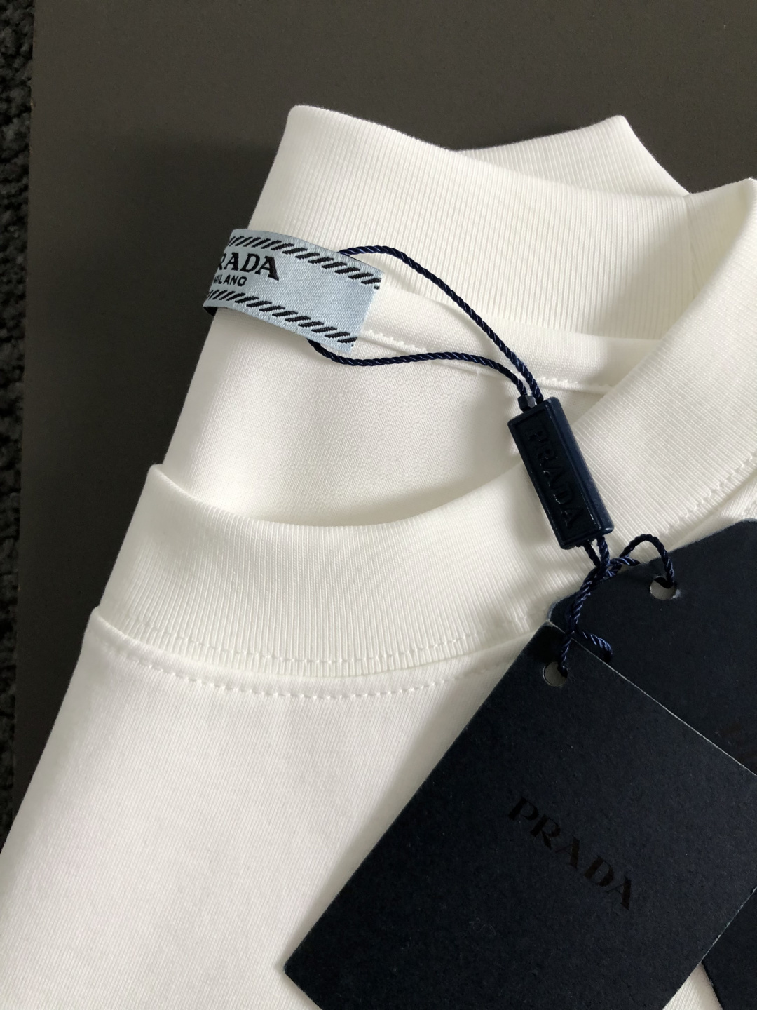 Prad*正码正拍M-xxxl2026春夏短袖，以黑白撞色为主调，巧妙融入植绒线条印花金属三角标元素，打