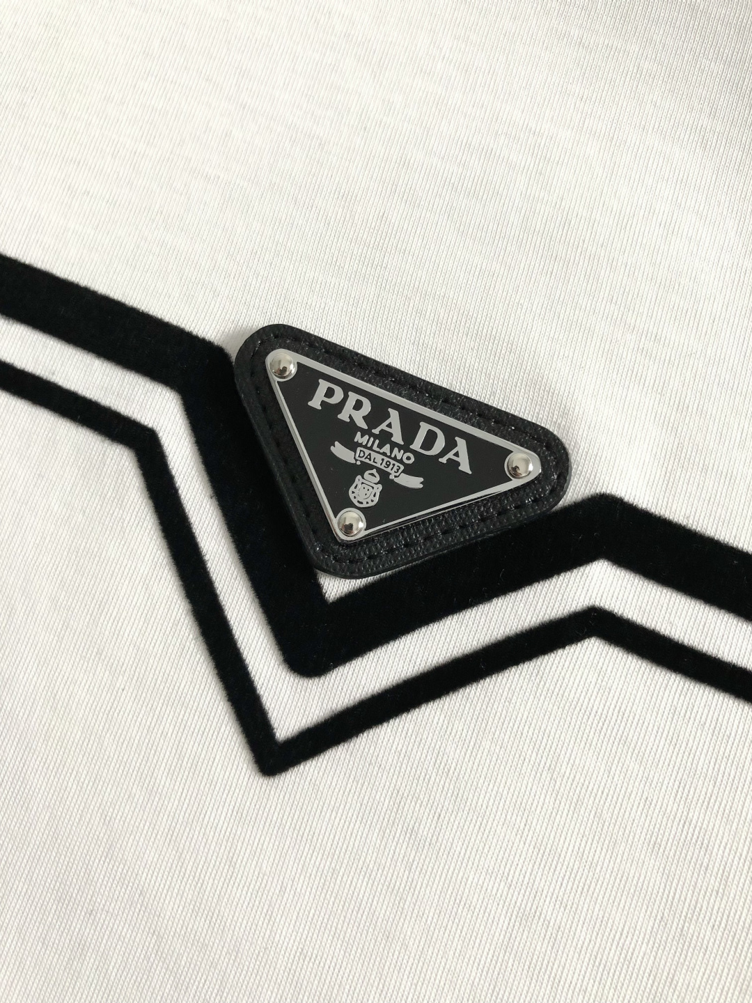 Prad*正码正拍M-xxxl2026春夏短袖，以黑白撞色为主调，巧妙融入植绒线条印花金属三角标元素，打
