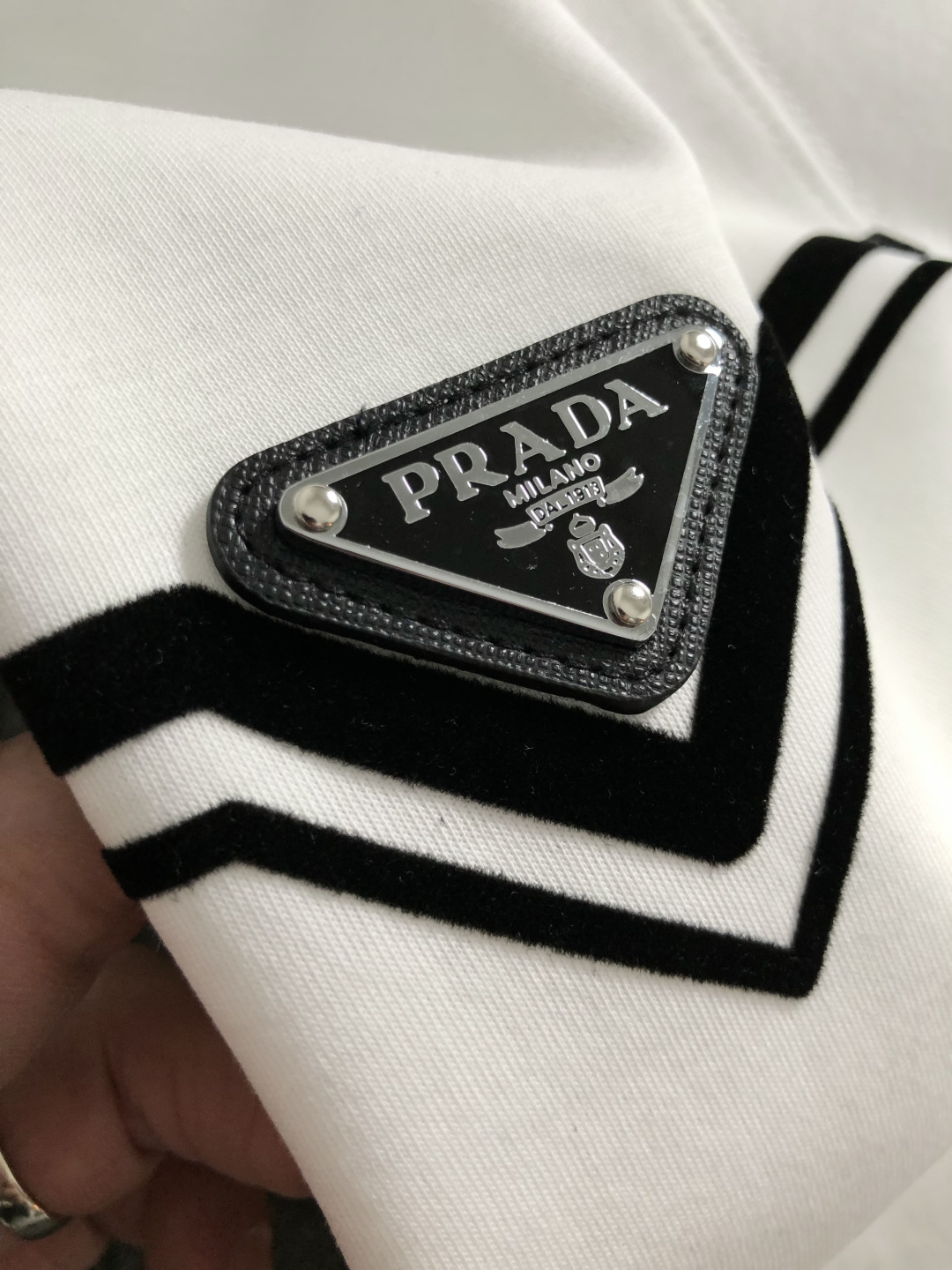 Prad*正码正拍M-xxxl2026春夏短袖，以黑白撞色为主调，巧妙融入植绒线条印花金属三角标元素，打