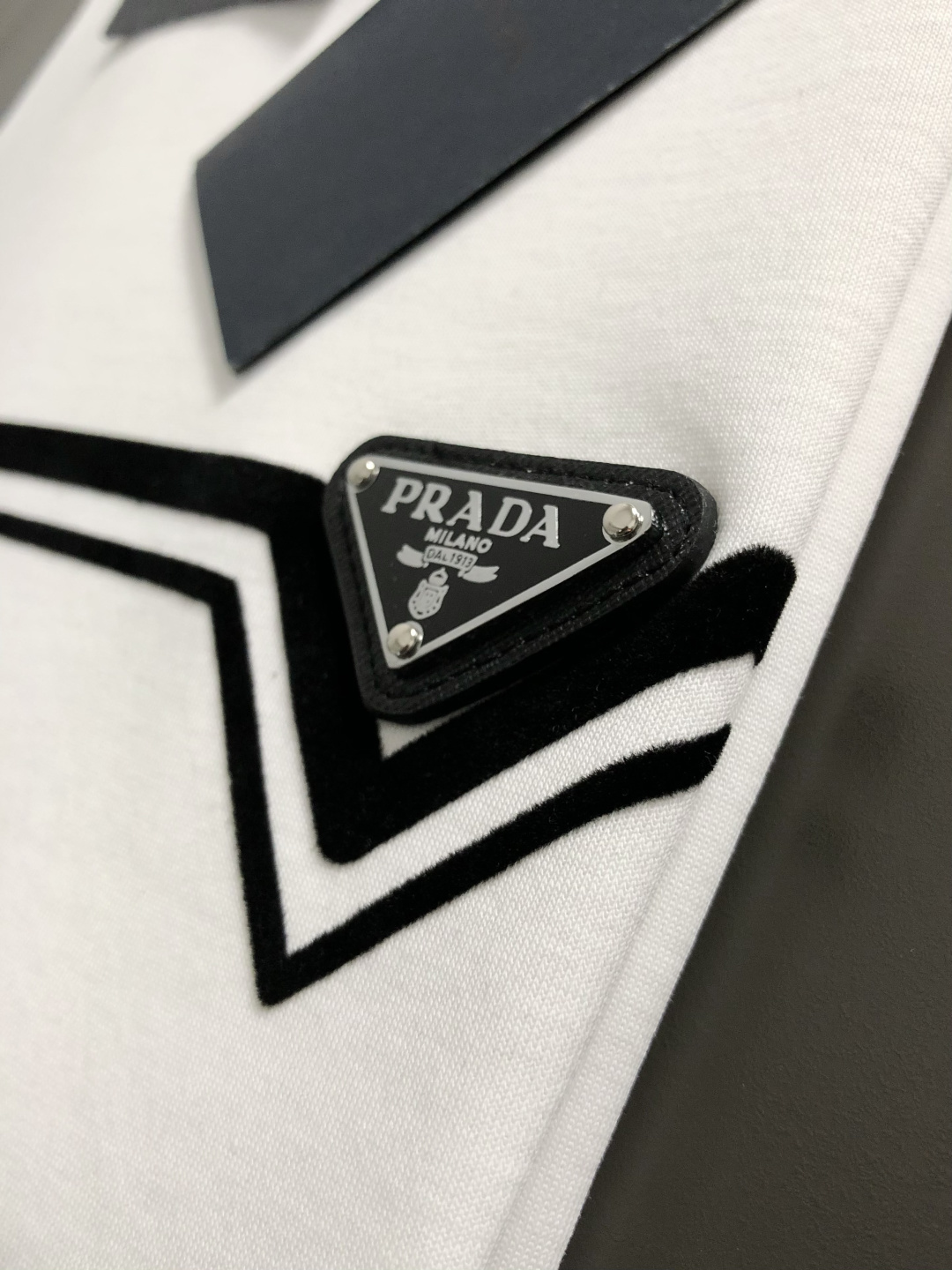 Prad*正码正拍M-xxxl2026春夏短袖，以黑白撞色为主调，巧妙融入植绒线条印花金属三角标元素，打