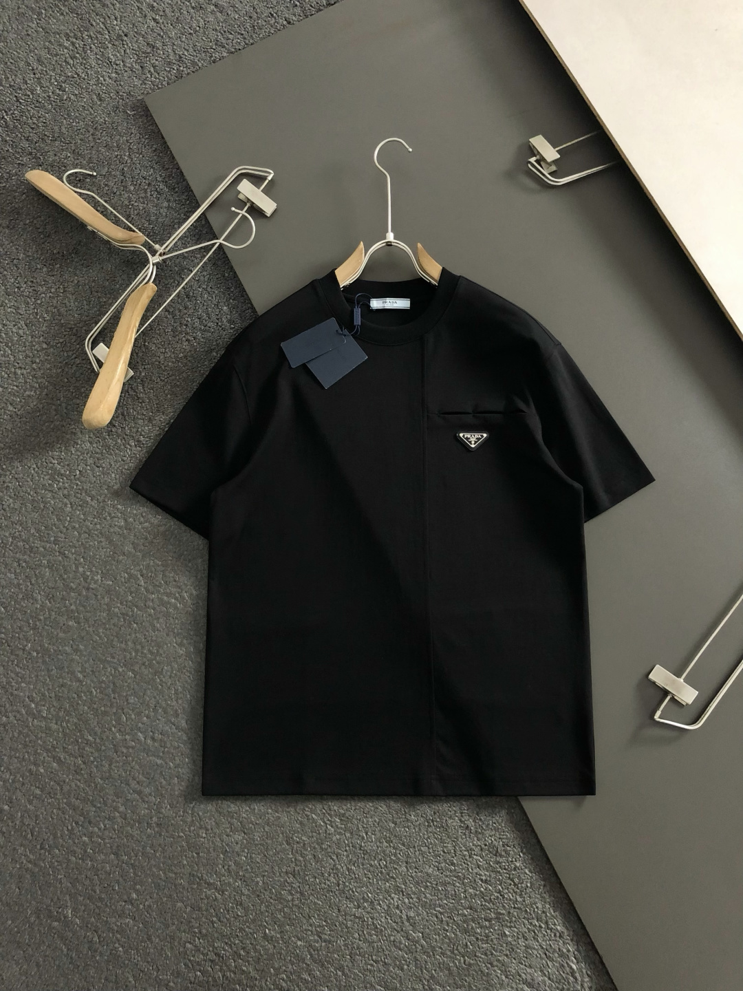 Prad*卡码拍小M-xxxl2026春夏短袖，以金属三角标口袋主调，巧妙融入后幅拼接面料元素，打破传统