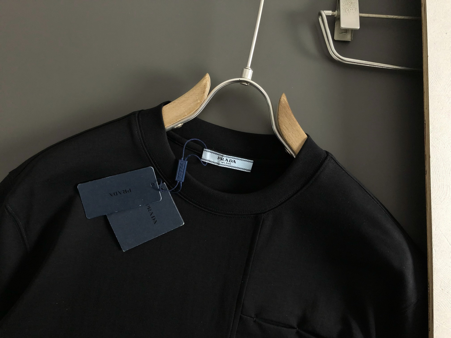 Prad*卡码拍小M-xxxl2026春夏短袖，以金属三角标口袋主调，巧妙融入后幅拼接面料元素，打破传统