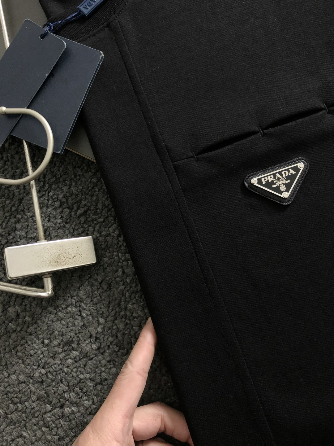 Prad*卡码拍小M-xxxl2026春夏短袖，以金属三角标口袋主调，巧妙融入后幅拼接面料元素，打破传统