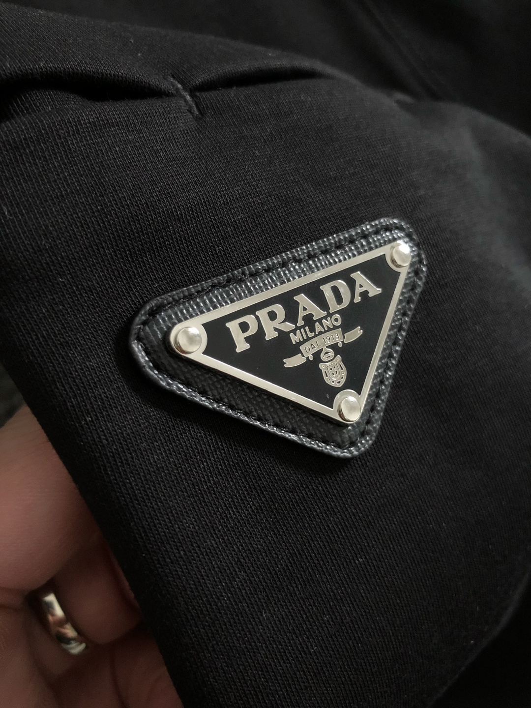 Prad*卡码拍小M-xxxl2026春夏短袖，以金属三角标口袋主调，巧妙融入后幅拼接面料元素，打破传统