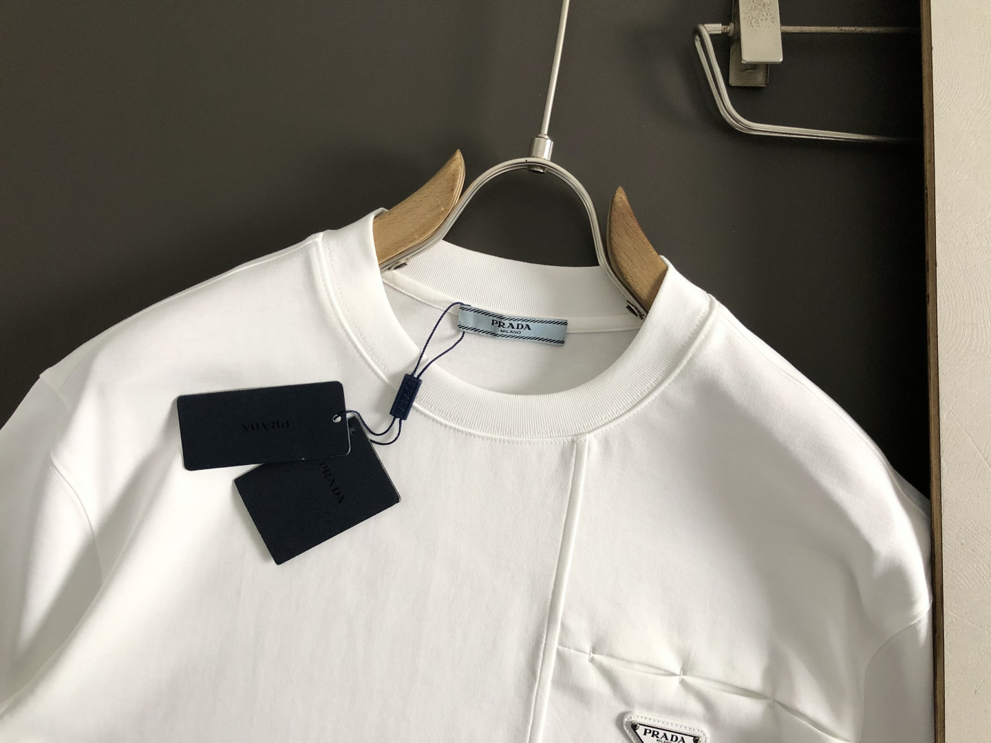 Prad*卡码拍小M-xxxl2026春夏短袖，以金属三角标口袋主调，巧妙融入后幅拼接面料元素，打破传统
