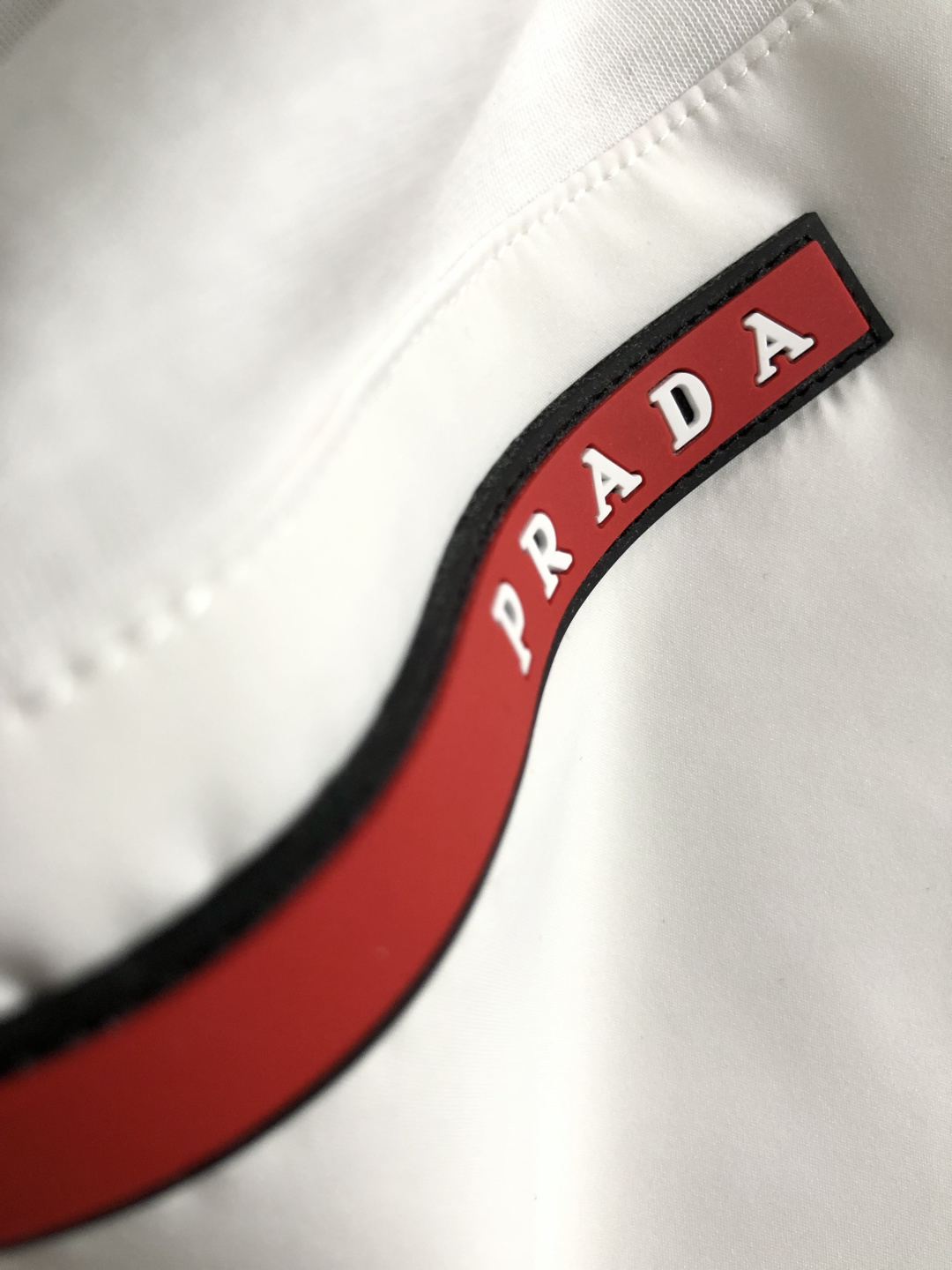 Prad*卡码拍小M-xxxl2026春夏短袖，以金属三角标口袋主调，巧妙融入后幅拼接面料元素，打破传统