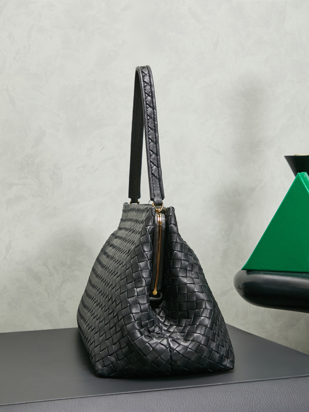 The 1998 gold clip handbag is named in tribute to the highlight of the brand's first show in Milan in 1998. It replicates the retro silhouette of the Frame Bag in the 1990s. The trapezoidal bag body is soft but not collapsed. It is made of Nappa lambskin with a dense and soft texture. The leather surface is delicate and wear-resistant. The top is opened and closed with an integrated metal square buckle. The sides are naturally slightly closed. It comes with a small mirror and the opening and closing method is calm and elegant. Minimalist design without logo, elegant and restrained, suitable for commuting or dinner, gentle and aura.
Style number: 868128
Color: black
Size: 37*18*16cm photo 1