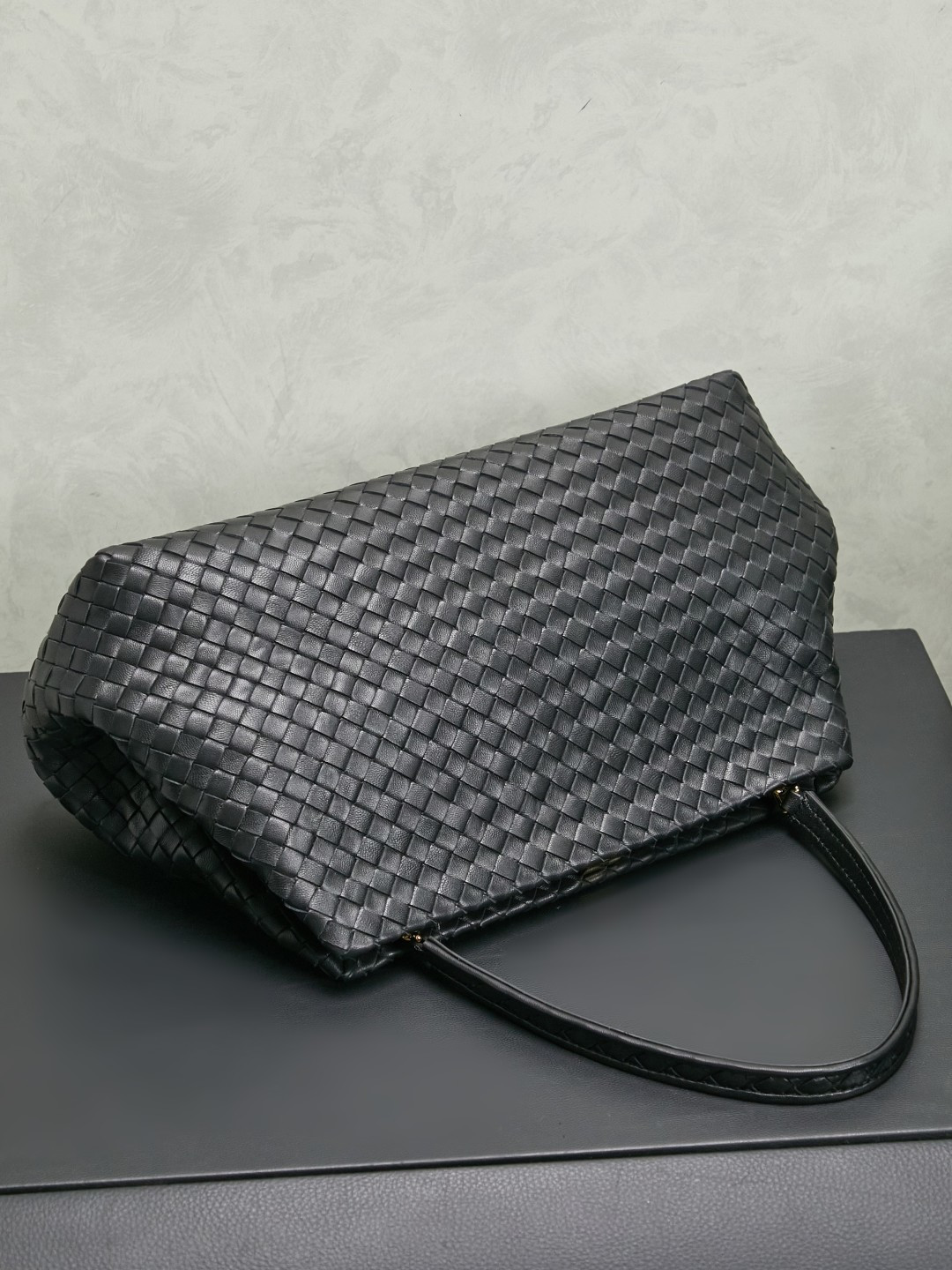 The 1998 gold clip handbag is named in tribute to the highlight of the brand's first show in Milan in 1998. It replicates the retro silhouette of the Frame Bag in the 1990s. The trapezoidal bag body is soft but not collapsed. It is made of Nappa lambskin with a dense and soft texture. The leather surface is delicate and wear-resistant. The top is opened and closed with an integrated metal square buckle. The sides are naturally slightly closed. It comes with a small mirror and the opening and closing method is calm and elegant. Minimalist design without logo, elegant and restrained, suitable for commuting or dinner, gentle and aura.
Style number: 868128
Color: black
Size: 37*18*16cm photo 4