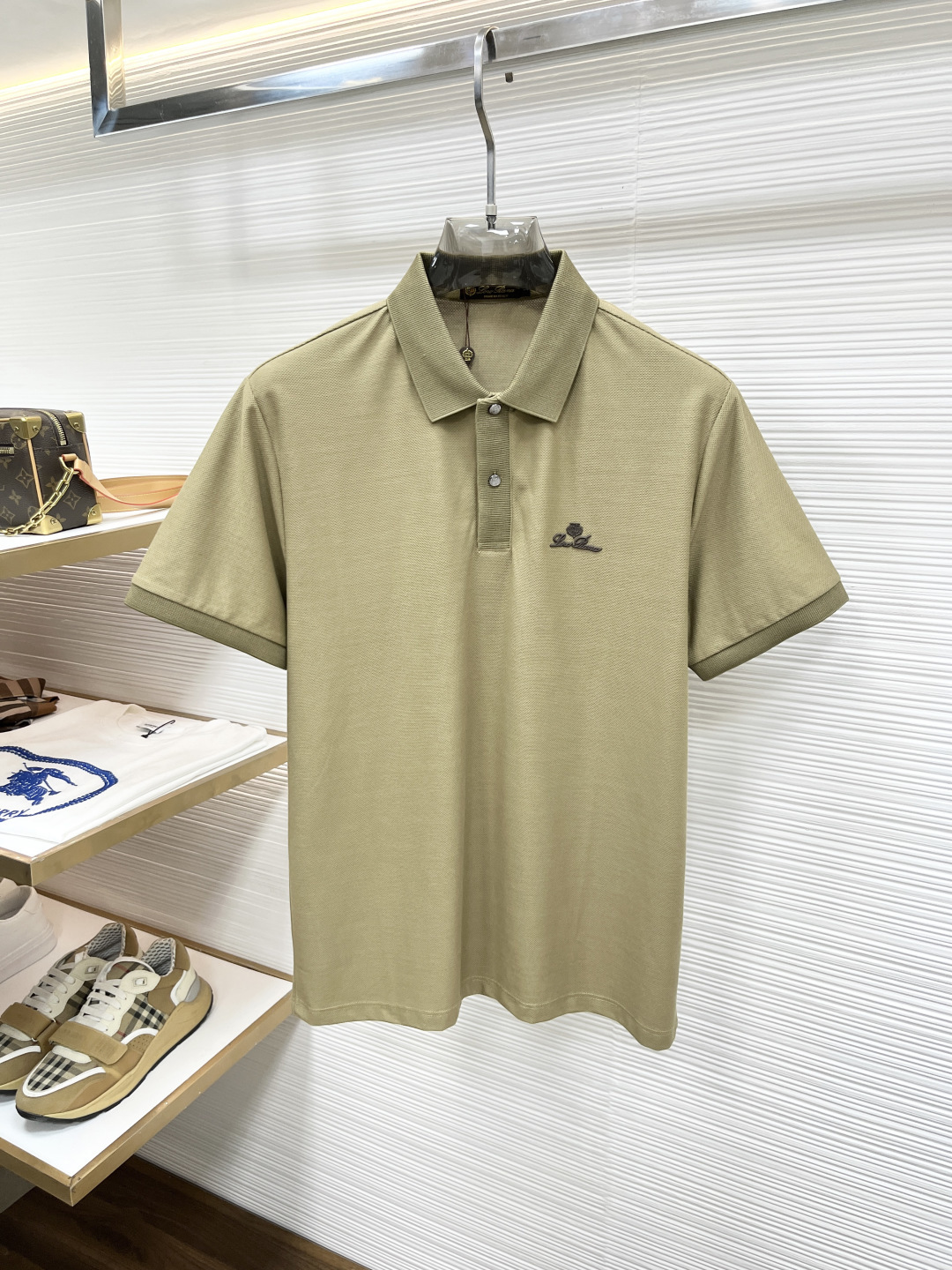 Loro Piana 春夏经典的Polo领设计，搭配简洁的单排扣，线条利落流畅，巧妙修饰颈部线条，彰显优