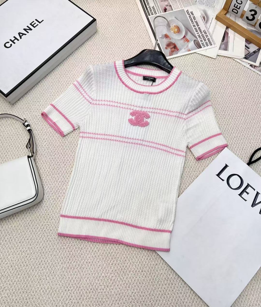 NO:314515,Chanel2025 new product is available on the shelves of round neck slim knitted short sleeves, customized YB imported yarn woven, delicate texture, soft and comfortable round neck knitted short sleeves cut, threaded edge wrap adds exquisite tone, full-body vertical pit strip knitted texture, elastic characteristics, fit the body and make it look slimmer Simple short-sleeved sweater, delicate and soft texture, skin-friendly and comfortable. The double C logo patch on the chest is eye-catching, and classic elements inject recognition and fashion into the shape. Black and white two colors are available, and the white style is outlined with pink lines, which is sweet and elegant; the black style is matched with white lines, simple and atmospheric. Whether it is matched with skirts or trousers, it can easily enhance the overall style and show the French elegant style. Large products are available Size sml, chanel, skirts, T-shirt, alexander wang19860909Chanel2025新品上架圆领修身针织短袖,定制YB进口纱线织造 细腻肌理 柔软舒适 圆领针织短袖裁剪 螺纹包边增添精致调性 通体竖坑条针织纹理 搭配弹性十足的特性 贴合身型更显瘦 简约短袖针织衫,质感细腻柔软,亲肤又舒适.胸前双C徽标贴片醒目吸睛,经典元素为造型注入辨识度与时尚感.黑白双色可选,白色款以粉色线条勾勒轮廓,甜美优雅；黑色款搭配白色线条,简约大气.无论是搭配裙装还是裤装,都能轻松提升整体造型格调,尽显法式优雅风情.大货出 尺码sml,,chanel,skirts,T-shirt,alexander wang,Women's clothing