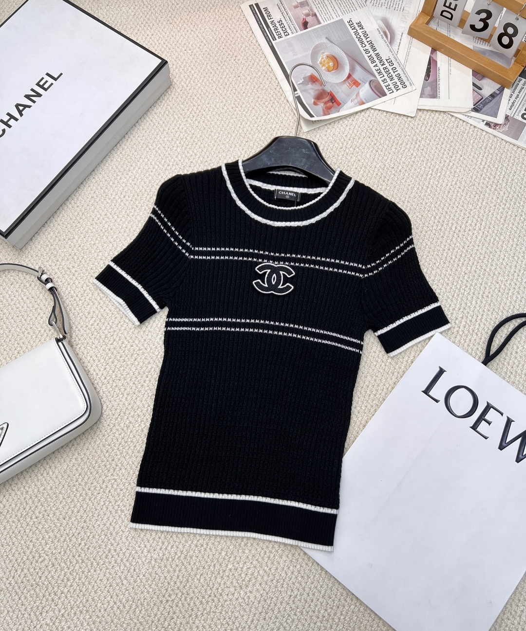 NO:314518,Chanel2025 new product is available on the shelves of round neck slim knitted short sleeves, customized YB imported yarn woven, delicate texture, soft and comfortable round neck knitted short sleeves cut, threaded edge wrap adds exquisite tone, full-body vertical pit strip knitted texture, elastic characteristics, fit the body and make it look slimmer Simple short-sleeved sweater, delicate and soft texture, skin-friendly and comfortable. The double C logo patch on the chest is eye-catching, and classic elements inject recognition and fashion into the shape. Black and white two colors are available, and the white style is outlined with pink lines, which is sweet and elegant; the black style is matched with white lines, which is simple and elegant. Whether it is matched with skirts or trousers, it can easily enhance the overall style and show the French elegant style. Large products are available Sizes sm, chanel, skirts, T-shirt, alexander wang19860909Chanel2025新品上架圆领修身针织短袖,定制YB进口纱线织造 细腻肌理 柔软舒适 圆领针织短袖裁剪 螺纹包边增添精致调性 通体竖坑条针织纹理 搭配弹性十足的特性 贴合身型更显瘦 简约短袖针织衫,质感细腻柔软,亲肤又舒适.胸前双C徽标贴片醒目吸睛,经典元素为造型注入辨识度与时尚感.黑白双色可选,白色款以粉色线条勾勒轮廓,甜美优雅；黑色款搭配白色线条,简约大气.无论是搭配裙装还是裤装,都能轻松提升整体造型格调,尽显法式优雅风情.大货出 尺码sm,,chanel,skirts,T-shirt,alexander wang,Women's clothing