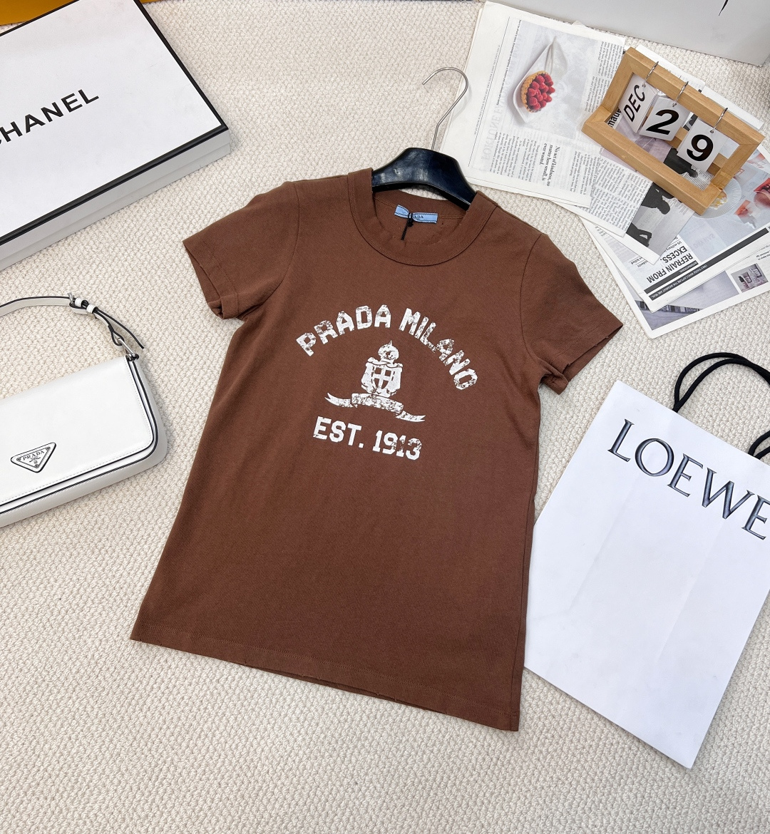 NO:310048,Prada2025 new round-neck letter printed T-shirt, customized YB twill cotton material, breathable and comfortable, full texture, regular short-sleeved T-shirt cut, highlighting the brand style, made of gram-weight pure cotton, slightly elastic, giving a slimming visual effect, iconic letters, logo shield pattern embellishment on the chest, the brand's own high-end fashion sense is instantly created, create a personal style at will, single wear, stylish, custom face accessories, accurate version, two colors, size sml code P,,prada, T-shirt,tees, t-shirt,alexander wang19860909Prada2025新款圆领字母印花T恤,定制YB斜纹全棉材质 透气舒适 质感十足 常规短袖T恤裁剪 凸显品牌格调 采用克重纯棉制成 略带有弹力 呈现显瘦视觉效果 胸前标志性字母徽标盾牌图案点缀 品牌自带的高级时尚感立现 随心打造个性风格 单穿内搭都出彩时髦 定制面辅料 认准版本两色出 尺码sml 编码P,,prada,T-shirt,tees，t-shirt,alexander wang,Women's clothing