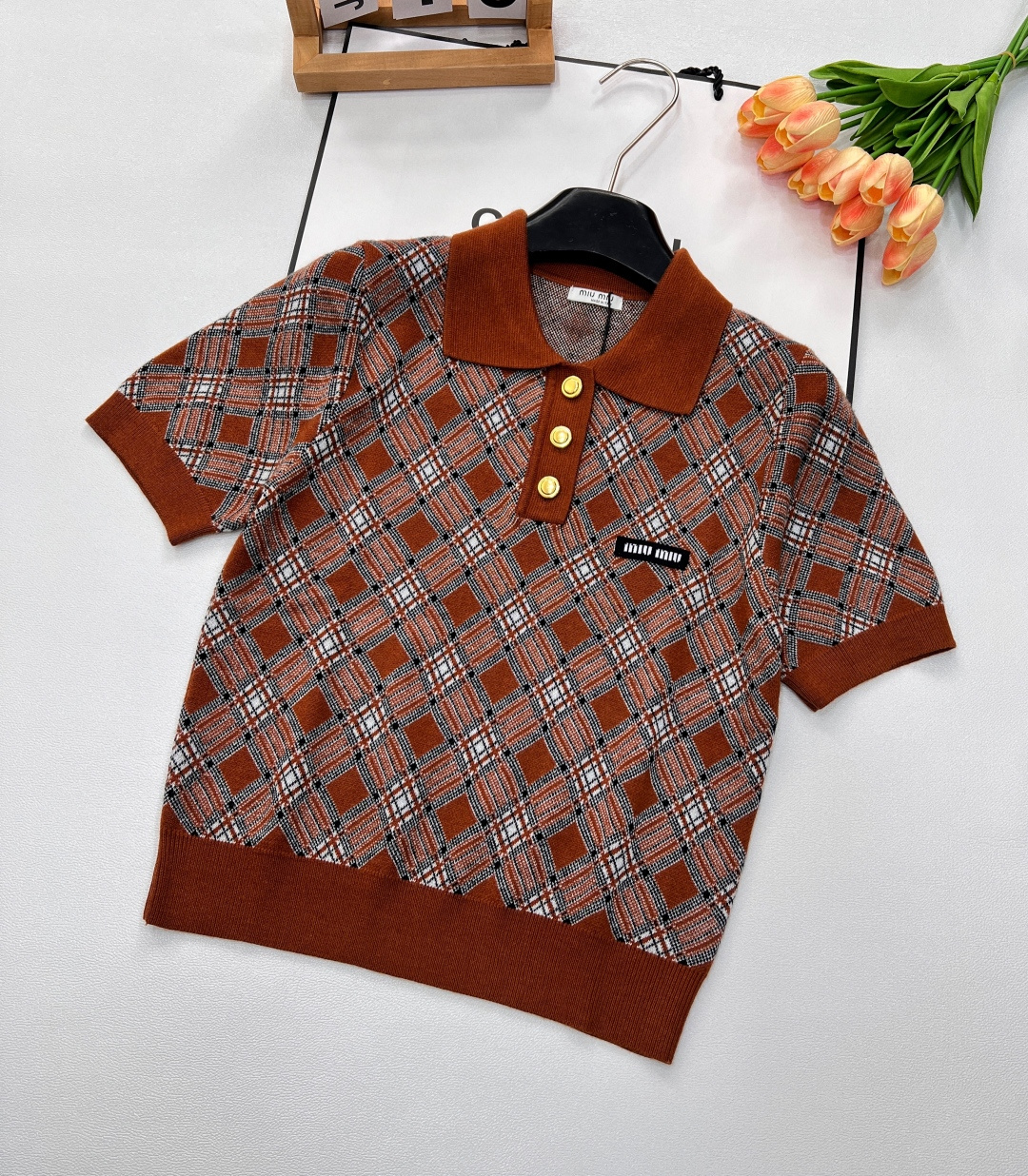 NO:331521,Miumiu's new diamond-shaped Polo collar knitted short sleeves are a rare fashion item in the wardrobe. The classic Polo collar design has an elegant and capable temperament, which modifies the neck lines and shows a neat and fashionable attitude. The diamond-shaped pattern is all over the body, and the retro college style is full. Each line shows craftsmanship, exquisite and unique, allowing retro and modern trends to collide here. The selected high-quality knitted fabrics are soft and delicate, and they are comfortable to fit the skin, with good breathability, and can keep them refreshing even in warm weather. The short style is cleverly in line with the current trend. It is matched with a high-waist bottom to easily create long legs and optimize the body proportions.  Whether it is paired with pleated skirts to create a sweet college style, or with jeans to create a casual and fashionable feeling, or a small suit for commuting occasions, it can be perfectly adapted to meet a variety of dressing needs and allow you to bloom unique charm in different scenes. Two colors are excellent. Size sml,,miumiu, skirts, jeans, T-shirt, business suit, alexander wang19860909miumiu新款菱格Polo领针织短袖,是衣橱中不可多得的时尚单品.经典Polo领设计,自带优雅干练气质,修饰颈部线条,展现出利落的时尚态度 .菱格纹图案遍布衣身,复古学院风拉满,每一格线条都彰显着匠心,精致又独特,让复古与现代潮流在此碰撞.精选优质针织面料,触感柔软细腻,贴肤穿着舒适亲肤,透气性佳,即使在温暖天气也能保持清爽 .短款版型,巧妙契合当下流行趋势,搭配高腰下装,轻松打造大长腿,优化身材比例. 无论是搭配百褶裙打造甜美学院风,还是配牛仔裤营造休闲时尚感,亦或是外搭小西装用于通勤场合,它都能完美适配,满足多样穿搭需求,让你在不同场景中绽放独特魅力.两色出 尺码sml,,miumiu,skirts,jeans,T-shirt,business suit,alexander wang,Women's clothing