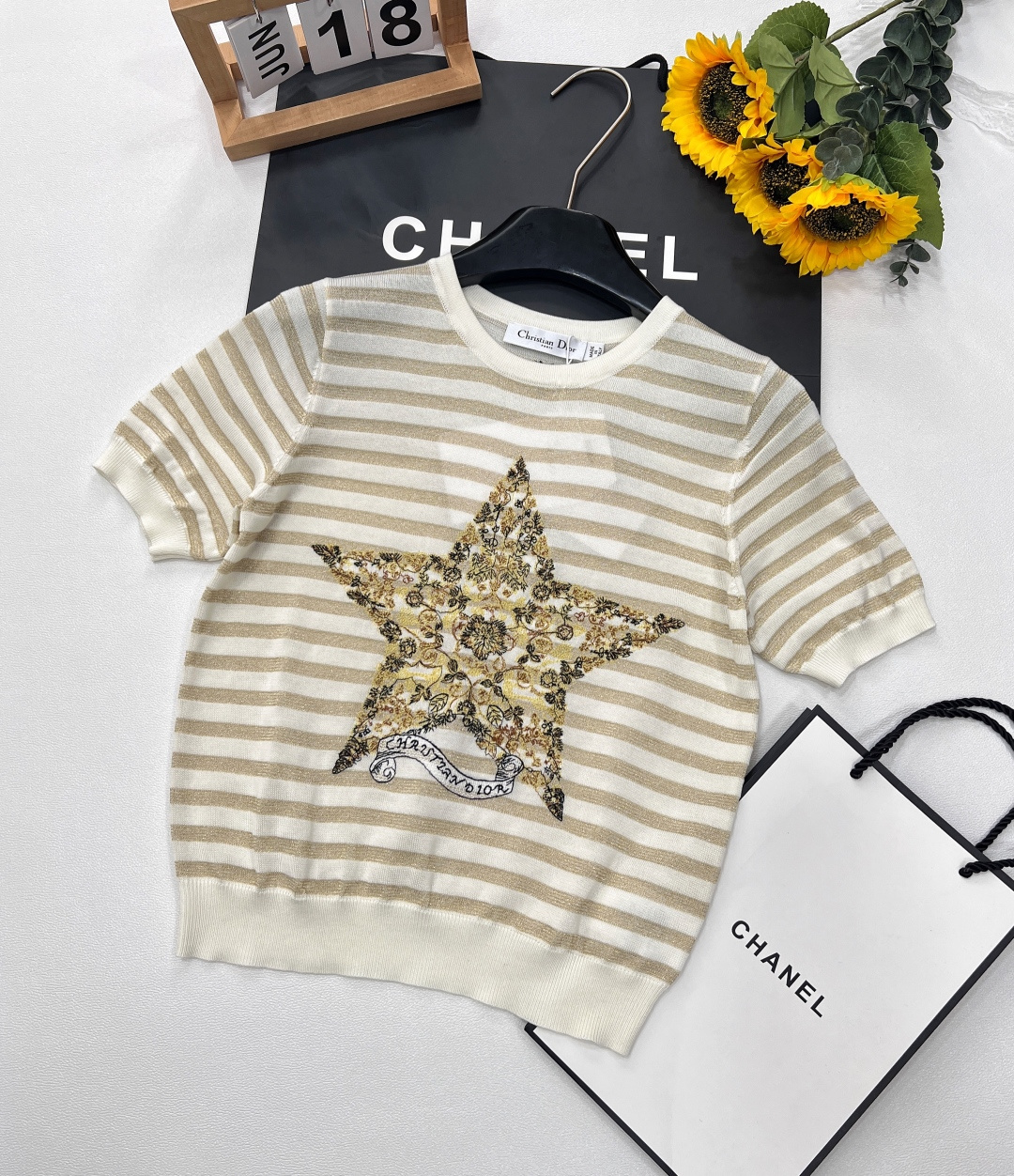 NO:328009,Dior's new five-pointed star ribbon knitted short sleeves perfectly blend luxury and fashion. The classic beige background is paired with shining golden stripes, interwoven with low-key and high-end texture. The iconic five-pointed star pattern is presented with complex and exquisite embroidery craftsmanship. Each pattern tells the ingenuity. It is matched with the word 
