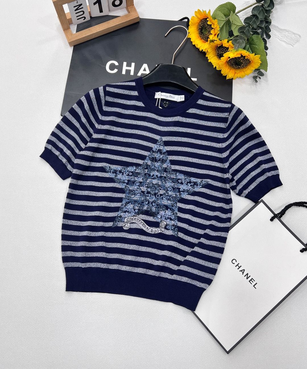 NO:328015,Dior's new five-pointed star ribbon knitted short sleeves perfectly blend luxury and fashion. The classic beige background is paired with shining golden stripes, interwoven with low-key and high-end texture. The iconic five-pointed star pattern is presented with complex and exquisite embroidery craftsmanship. Each pattern tells the ingenuity. It is matched with the word 