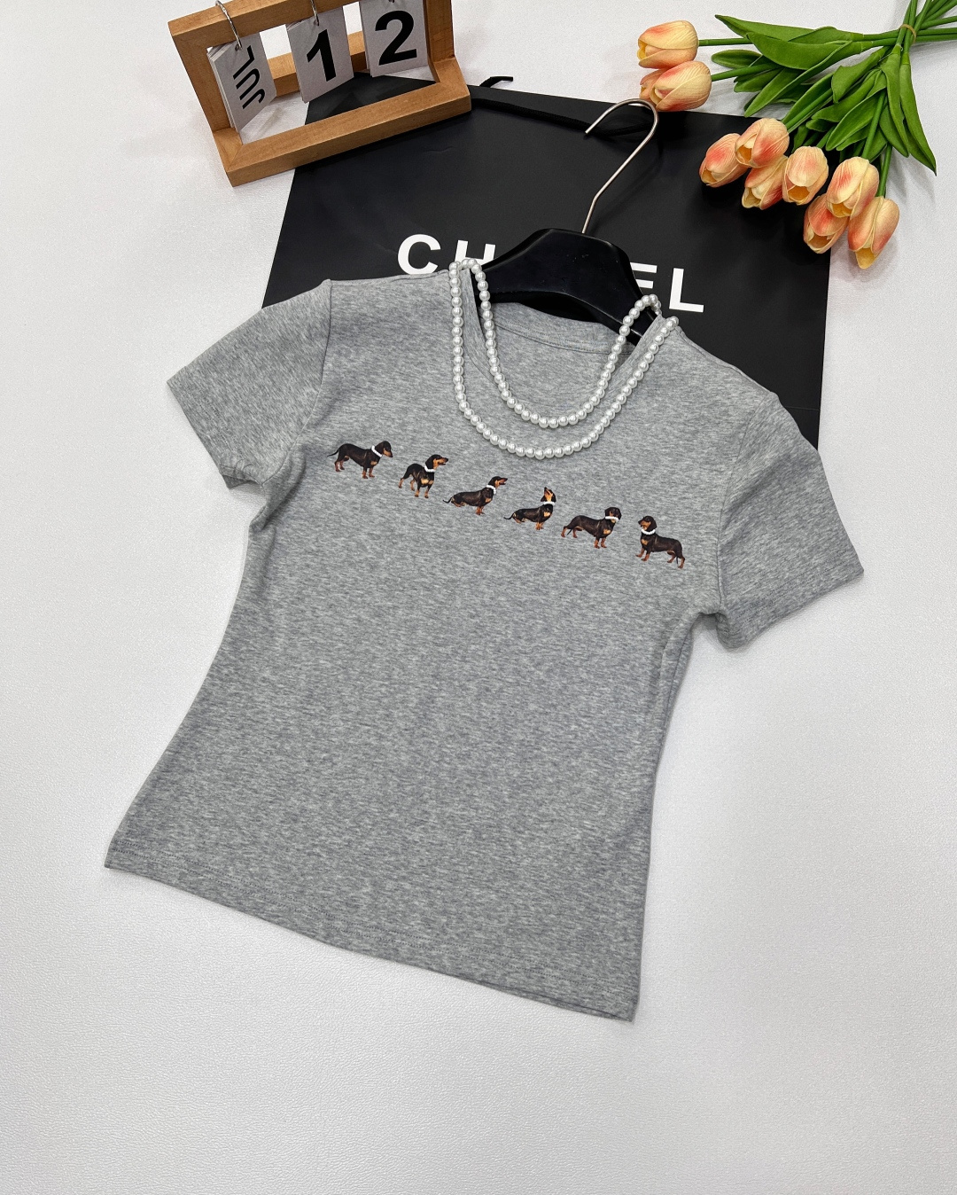 NO:328608,Markgong designer brand Jennie is the same style as pearl necklace dachshund dog slim short-sleeved T-shirt. This T-shirt is based on high-end combed cotton. It is delicate and skin-friendly and breathable. It incorporates a detachable pearl necklace to cleverly add elegant temperament and give more possibilities to wear. Every puppy is different. They all wear exquisite beaded necklaces. Unique design highlights the agility and fun of the pattern. Each puppy has a classic shoulder-mounted style, modifying the body to show proportions. It is slim and elastic, and the upper body is super slim. It is unique and fashionable and unique. Simple but full of street fashion. It is matched with cute dachshund dogs and exquisite waist-hugging tailoring. Once worn, it immediately gives the fresh and cool feeling of a Korean lady!  Size sml code, T-shirt,tees,t-shirt,necklace,alexander wang19860909Markgong设计师品牌Jennie同款配珍珠项链腊肠狗修身短袖T恤 此款T恤以高级精梳棉为基底 质感细腻且亲肤透气 融入了可拆卸的珍珠项链 巧妙增添优雅气质,同时赋予穿搭更多可能性 每只小狗都不一样 均佩戴精致串珠项链 独特设计 凸显图案的灵动与趣味每只小狗 经典正肩版型 ,修饰身材显比例.修身弹性,上身超级显瘦 别致又时髦有个性 简约却充满街头时尚感,搭配可爱的腊肠狗和收腰的精致剪裁,一穿上立马有那种韩国小姐姐的清新又酷感！ 尺码sml 编码,,T-shirt,tees，t-shirt,necklace,alexander wang,Women's clothing