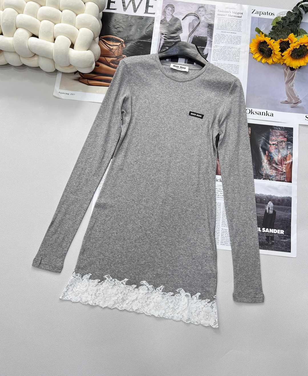 NO:417073,MiuMiu 25Ss spring and summer new micro-label lace spliced ​​long sleeve mid-length T-shirt, customized fabric, the upper body is super comfortable and breathable. The classic round neck design smoothly fits the neck lines, exuding a simple and generous temperament. The brand logo patch is low-key embellished by the side, which seems to be an inadvertent elegant expression, but it accurately demonstrates the brand style and identity. It is a silent announcement of fashion attitude. The lace splicing design at the hem injects romantic factors into the overall simple style. The exquisite lace patterns are created with delicate craftsmanship, light and layered, and appear and appear when walking, which is touching the hearts of the details, and interprets the softness and elegance of women just right.  Mid-length style and long-sleeved design give it a variety of possibilities for wear. When wearing it alone, paired with simple jeans or skirts, you can easily create a casual or light-hearted style. As an inner layer, it can add layering and exquisiteness to the knitted cardigans and blazers. Whether it is commuting, date or casual party, it can help you become the focus. White and gray colors are available in size sml code, miumiu, skirts, jeans, jackets & coats, tees, t-shirt, business suit, alexander wang19860909MiuMiu 25Ss春夏新款微标蕾丝拼接长袖中长款T恤,定制的面料,上身超舒服透气.经典圆领设计,流畅贴合颈部线条,散发简约大方气质.品牌logo贴布低调点缀于身侧,似不经意间的优雅流露,却又精准彰显品牌格调与身份,是时尚态度的无声宣告. 下摆处蕾丝拼接设计,为整体简约风格注入浪漫因子.精致蕾丝花纹,以细腻工艺打造,轻盈且富有层次感,走动间若隐若现,于细节处撩动人心,将女性的柔美与优雅诠释得恰到好处. 中长款版型与长袖设计,赋予它多样穿搭可能性.单穿时,搭配简约牛仔裤或半身裙,就能轻松打造日常休闲或轻熟风造型；作为内搭叠穿在针织开衫、西装外套内,又能增添层次感与精致感,无论是通勤、约会还是休闲聚会,都能助您成为焦点,白色灰色两色出 尺码sml 编码,,miumiu,skirts,jeans,jackets & coats,tees，t-shirt,business suit,alexander wang,Women's clothing