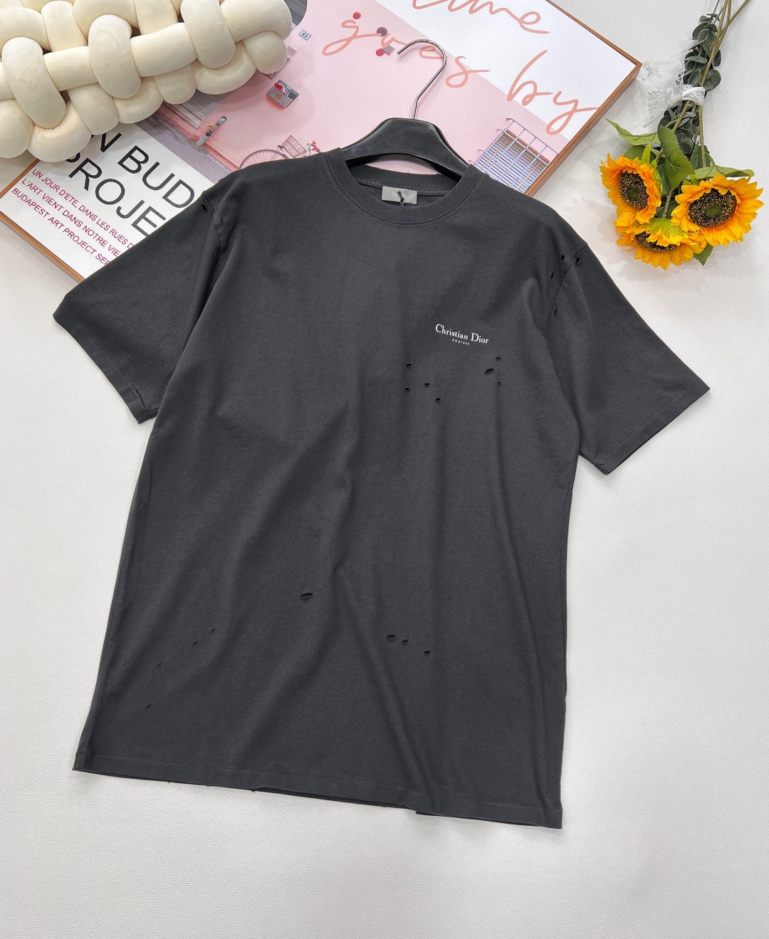 NO:421892,DIOR25SS new ripped old lily of the valley printed round neck short sleeves, fabric made of pure cotton natural fiber has good hygroscopicity, strong breathability, soft and comfortable properties. Cotton fabrics are usually suitable for summer wear and can help keep the body dry and comfortable. Yarn alternately passes horizontally and vertically to form a simple cross structure; it has good elasticity and wear resistance. Decorated with the full name logo and lily of the valley printed pattern, imported powder slurry printing process, which achieves a delicate color transition through special slurry formula and precision processing, and reduces the color layer of the petals. For tulle fabrics, light diffuser is added to the powder slurry to make the printing area appear matte matte matte, which contrasts with the transparent background.  The fabric is specially pretreated to create a natural wear and fading effect. During the sewing process, special sewing techniques and stitch density are used to enhance the durability and natural feeling of the short-sleeved sleeves. A combination of machine wear or manual scratching is used to create slight wear marks on the surface of the ready-made garment to increase the authenticity of the antique effect. Round neck short-sleeved T-shirts are reprinted on the neckline and cuff design, and special sewing methods or reinforcement treatments are used to ensure the durability and comfort of these parts. Standard casual round neck short-sleeved sleeves usually adopt a classic round neck design, with a moderate neck size, neither too tight nor too loose, and can well show the wearer's neckline lines. The same style for men and women, three standards are complete!  Size xssml encoding,dior,T-shirt,tees,t-shirt,alexander wang19860909DIOR25SS新款破洞做旧铃兰印花圆领短袖,纯棉天然纤维制作的面料,具有吸湿性好、透气性强、柔软舒适等特性.棉质面料通常适合夏季穿着,可以帮助保持身体干爽和舒适.纱线在水平和垂直方向上交替穿过,形成简单的交叉结构；具有较好的弹性和耐磨性. 饰以全称标识与铃兰印花图案 进口粉浆印花工艺制作,通过特殊浆料配方与精密加工实现细腻色彩过渡,还原花瓣的色泽层次.针对薄纱面料,粉浆添加光扩散剂,使印花区域呈现哑光雾面,与透明底色形成对比. 面料经过特殊的预处理,以营造出自然的磨损和褪色效果.缝制过程中,采用特殊的缝纫技术和线迹密度,以增强短袖的耐用性和自然感.采用机器磨损或手工刮擦两者结合的方法,在成衣表面制造出轻微的磨损痕迹,增加仿旧效果的真实感. 圆领短袖T恤在领口和袖口的设计上开版还原,采用特殊的缝制方法或加固处理,以确保这些部位的耐用性和舒适度.标准休闲圆领短袖通常采用经典的圆领设计,领口大小适中,既不会过于紧绷也不会过于宽松,能够很好地展现穿着者的颈部线条.男女同款,三标齐全！ 尺码xssml 编码,,dior,T-shirt,tees，t-shirt,alexander wang,Women's clothing