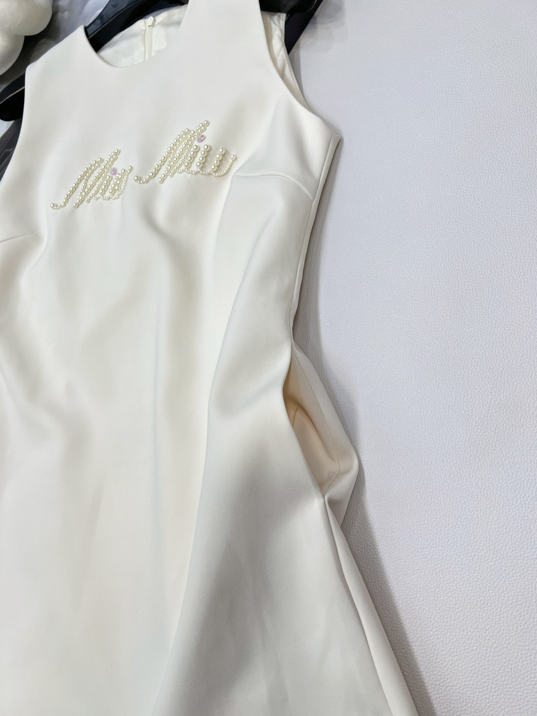 🆕Miumiu新款珍珠字母串珠无袖连衣裙✨ 简洁无袖线条，利落勾勒肩颈美感，自带松弛又高级的气场💫 胸前