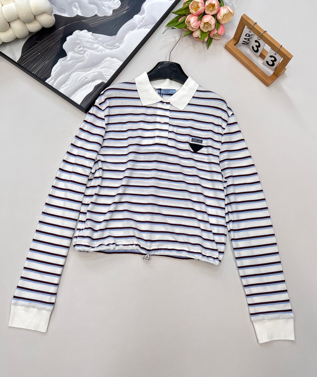 NO:434535,Prada25Ss new striped short drawstring long-sleeved Polo shirt丨Exclusive high-end production!  Pure cotton material has a comfortable and delicate texture, neat and loose cut, short vertical cut at waist, combined with the design of this cloth drawstring, adjust at will to achieve a waist-hugging effect, highlighting the proportional advantages of short upper and long lower. Triangular logo decoration is added between the back collar. The brand texture is full of exquisite atmosphere. The exquisite moment. The basic model that can be used for daily commuting and vacation. The quality of workmanship depends on the details!  Complete three standards, large-scale products, size sml code, prada, alexander wang19860909Prada25Ss新款条纹短款抽绳长袖Polo衫丨独家高版出品！纯棉材质质感舒适细腻 裁剪利落宽松版型 腰间短款立裁 配合本布抽绳系带设计 随意调节起到收腰效果 更凸显上短下长的比例优势 后领间增加三角徽标装饰 品牌质感充满精致气息 精致度瞬间 日常通勤度假都可驾驭的基础款 做工品质看细节！三标齐全,大货出 尺码sml 编码,,prada,alexander wang,Women's clothing