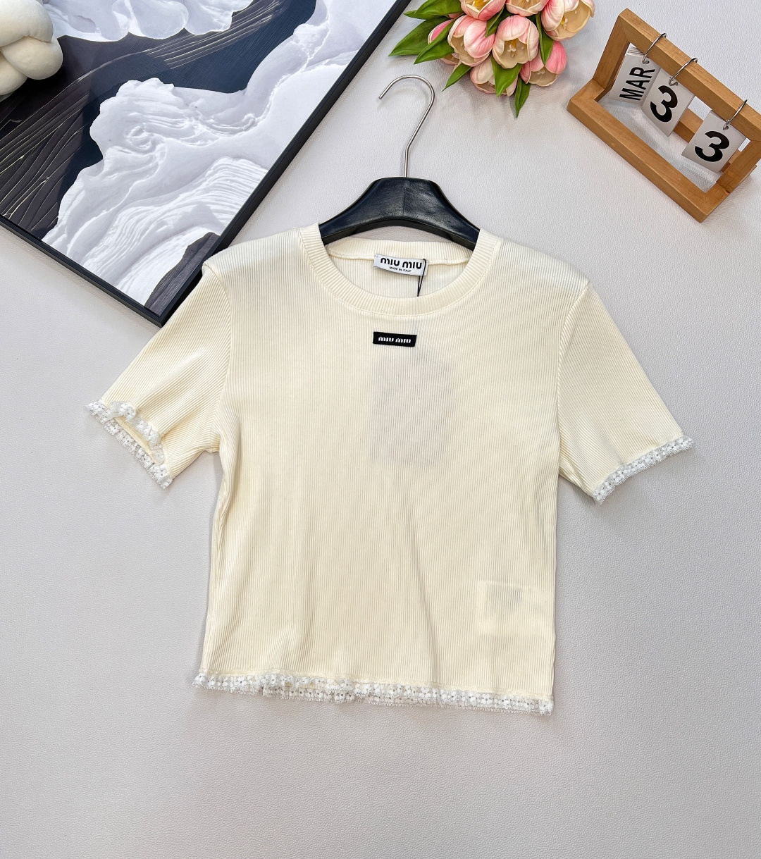 NO:434563,Miumiu25Ss' new lace lace threaded short-sleeved T-shirt, full of sweet atmosphere. Who can refuse the obedient and coquettish short-sleeved?  This piece of Miao Miao is directly conquered. The vertical pit strips hide the flesh and make you look slim. It has a delicate texture and is full of lazy literary sense. The lace lace splicing cuffs + hem embellishes exquisite lace, sweet and cool collision. The details control ecstasy, gentle and playful. The letter logo patch is classic Miao Miao logo with low-key finishing touch, and the sense of high-end is hard to grasp. The short style raises the waistline and shows the length of legs. It is suitable for various bottoms, which can be worn on daily/date/on the street, and can be easily controlled and relaxed and fashionable. The fabric is soft and glutinous and skin-friendly, and the elasticity is not slim online. It is superb when wearing it in early spring and layering. Whoever wears it is the sweet bean on earth? Miao Miao girl is quick lock!  Complete three standards, large-scale goods, size sml code, miumiu, T-shirt,tees, t-shirt,alexander wang19860909Miumiu25Ss新款蕾丝花边螺纹短袖T恤、甜飒氛围拉满 谁能拒绝又乖又嗲的短袖？缪缪这件直接封神 竖坑条纹理藏肉显瘦一把手,自带细腻质感,慵懒文艺感拉满 蕾丝花边拼接袖口+下摆点缀精致蕾丝,甜飒碰撞 细节控狂喜,温柔又俏皮 字母徽标贴片经典缪缪标识低调点睛,高级感狠狠拿捏 短款版型拉高腰线显腿长 适配各种下装,日常/约会/出街都能穿,轻松拿捏松弛时髦 面料软糯亲肤,弹力在线不勒肉～ 早春单穿、叠穿都超绝,谁穿谁是人间小甜豆 缪缪女孩速锁！三标齐全,大货出 尺码sml 编码,,miumiu,T-shirt,tees，t-shirt,alexander wang,Women's clothing