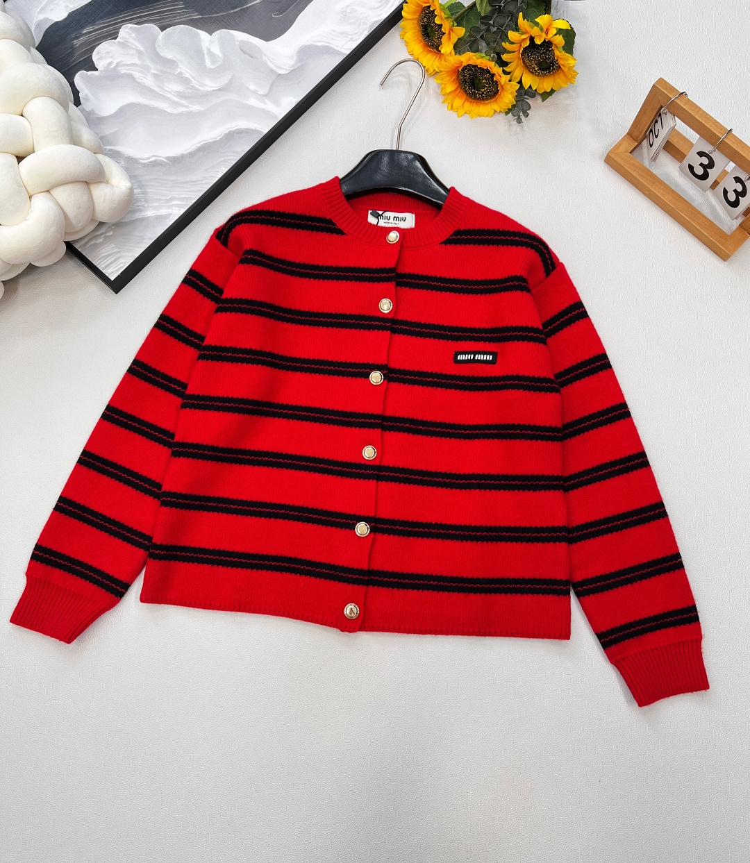 NO:445933,MIUMIU letter patch striped gold button cardigan, classic logo contrast striped cardigan, super bright red, white and noble. It is woven with imported German machine. Wool feels soft and comfortable to touch. Super beautiful~ Metal button closure, ribbed neckline and hem design, many details show the temperament of the miu series. Easy to match with various items, whether it is inner or outer, you can easily control the lazy and retro charm of the early autumn style. Contrast stripes create a nautical style, fashionable and eye-catching, simple and leisurely blend the modern atmosphere. Reinterpret the basic style with a different detail design. Red and black striped contrast splicing. Embroidered logo patches add iconic elements. Add fashionable attitude, loose tailoring with golden button plaids. The festive atmosphere is full to create a recognizable retro style!  Two colors size sml code, miumiu, alexander wang19860909MIUMIU 字母贴片条纹金扣开衫,经典徽标logo撞色条纹开衫,超亮眼的红色,显白又贵气. 采用德国进口机编织 绵羊毛触感柔软舒适 超好看的～ 金属纽扣开合,罗纹领口和下摆的设计,超多细节展现miu系的气质.轻松搭配各种单品,不论是内搭还是外披,都能让你轻松驾驭初秋的慵懒与小香风的复古韵味. 撞色条纹打造航海风格 时髦吸睛 简约闲适糅合摩登氛围 以别样的细节设计重释基础款式 红黑条纹撞色拼接 刺绣徽标贴饰增添标志性元素 平添时髦态度,金色纽扣开襟的宽松剪裁 节日气氛拉满 塑造极具辨识度的复古格调！两色出 尺码sml 编码,,miumiu,alexander wang,Women's clothing