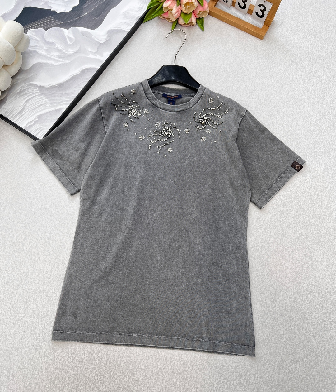 NO:446957,LOUIS VUITTON's new style of fried color made of old gray diamond short sleeves, unlocking a new height of summer fashion!   When classic gray meets the unique stir-frying and old craftsmanship, say goodbye to monotony in an instant. Each texture tells the unique retro charm, showing high-end texture in low-key, and easily becomes the focus of the streets and alleys. The carefully decorated diamonds on the shoulders and necklines are like the stars in the night sky, exquisite and yet ostentatious. Each diamond is carefully selected and arranged, reflecting charming light in the sun, adding a gorgeous fashion element to the simple short sleeves. Whether it is daily travel or partying, you can shine. This short sleeve is selected from soft and breathable cotton knitted fabric, which feels delicate and silky, as comfortable as the second layer of skin. In the hot summer, it can quickly sweat and breathe, keep the body dry at all times, and say goodbye to the stuffy and sticky feeling. Whether you are strolling on the street or doing outdoor activities, you can enjoy coolness and freedom.  A short-sleeved piece that combines retro, gorgeousness and comfort is an indispensable fashion item in this summer wardrobe, allowing you to easily interpret unique styles and meet a different kind of self!  Complete three standards!  Large goods are shipped!  Size sml encoding, louis vuitton, T-shirt,alexander wang19860909LOUIS VUITTON新款炒色做旧灰定钻短袖,解锁夏日时尚新高度！  当经典灰色遇上独特炒色做旧工艺,瞬间告别单调,每一处纹理都诉说着独有的复古韵味,低调中尽显高级质感,轻松成为街头巷尾的焦点. 肩部与领口精心点缀的定钻,如夜空中闪烁的星辰,精致而不失张扬.每一颗钻石都经过精心挑选与排布,在阳光下折射出迷人光芒 ,为简约的短袖增添了华丽的时尚元素,无论是日常出行还是参加聚会,都能让你光彩照人. 这件短袖甄选柔软透气的棉质针织面料,触感细腻丝滑,仿若第二层肌肤般舒适.炎炎夏日,它能快速排汗透气,让身体时刻保持干爽,告别闷热黏腻感 ,无论是漫步在街头,还是进行户外活动,都能畅享清凉与自在. 一件短袖,融合复古、华丽与舒适,是这个夏天衣橱中不可或缺的时尚单品,让你轻松演绎独特风格,邂逅别样的自己！三标齐全！大货出！ 尺码sml 编码,,louis vuitton,T-shirt,alexander wang,Women's clothing
