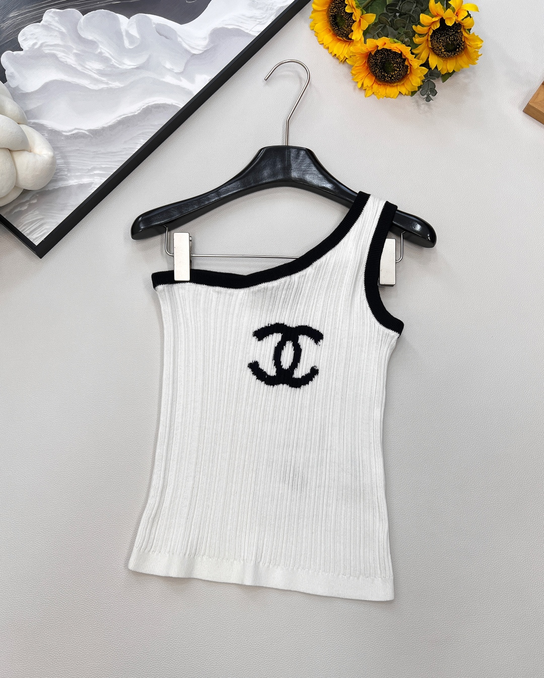 NO:449353,CHANEL2025 new logo jacquard slanted shoulder knit vest, customized YB wool yarn wool, comfortable and soft, full of elasticity, off-shoulder knit vest style, single side off-shoulder neckline, vertical pit strip texture is wrapped in contrasting colors to improve skin exposure and make it look slim and sexy. The design is rich in layering. The iconic logo logo is embellished on the chest to highlight the brand's high-end style, comfortable and elastic, adding retro charm to the outfit. No need to deliberately add decoration to show the fashionable outfit. Fashionable Hong Kong style, customized surface accessories, accurate version, high version, 2 colors, complete three standards!  Size sml code, chanel,alexander wang19860909CHANEL2025新款logo提花斜肩针织背心,定制YB羊毛纱线织造 舒适软糯 弹力十足 斜肩针织背心版型 单侧斜肩领口 竖坑条肌理以撞色包边包裹固定 提升露肤度显瘦性感 设计层次感丰富 胸前位置点缀标志性logo标 彰显品牌高级格调 舒适有弹力 为穿搭增添复古魅力 无需刻意加饰 即可彰显穿搭洋气感 时髦港风 定制面辅料 认准版本 高版本 2色出,三标齐全！ 尺码sml 编码,,chanel,alexander wang,Women's clothing