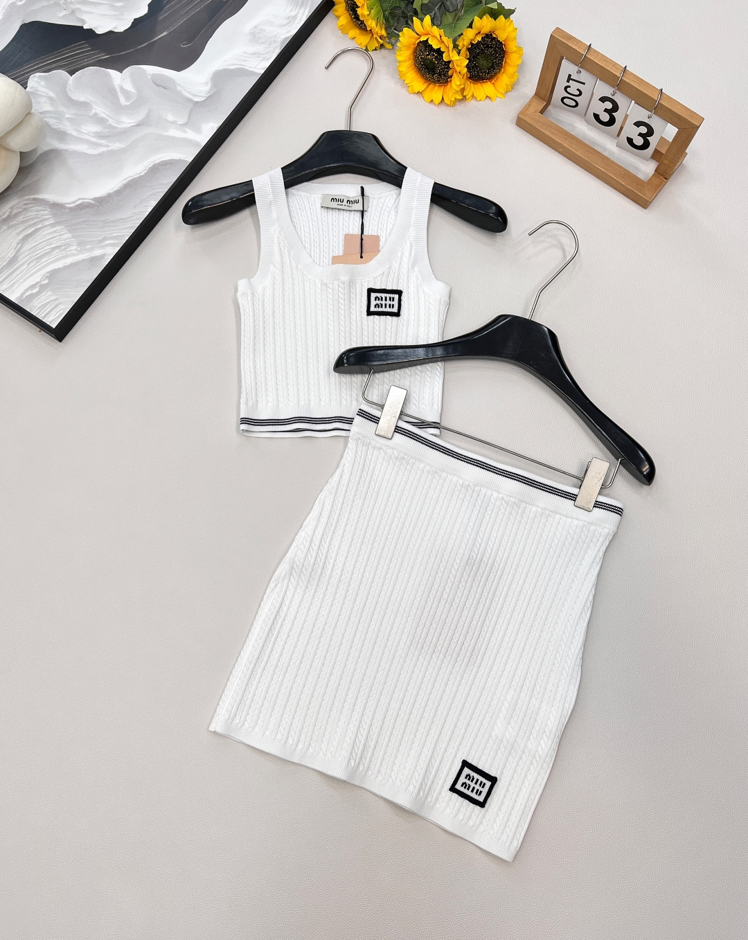 NO:452024,Miu Miu's new knitted vest skirt suit, with a slack and fashionable feeling, milky white knitted fabric comes with exquisite filters, the iconic logo finishes the touch, and the atmosphere is full. The short vest cannot hide the waist and the good proportions cannot be hidden. The skirt wraps the body and hides the flesh and is neat, suitable for multiple scenes. It is refreshing and expensive to wear in summer. Wearing a small jacket seamlessly connects early autumn. The fashionable 'airy outfit' is easy to grasp. Whoever wears it will win the hemp~ The three standards are complete, and one set is out!  Not only out!  Large-scale size sml code, miumiu, skirts, jackets & coats, alexander wang19860909Miu Miu 新款针织背心半裙套装,松弛时髦感狠狠拿捏奶白针织面料自带精致滤镜,标志性徽标点睛,氛围拉满 短背心露腰藏不住的好比例,半裙裹身藏肉又利落,适配多场景 夏天单穿清爽显贵,搭小外套无缝衔接早秋,时髦精的「空气感穿搭」,靠它轻松拿捏,谁穿谁赢麻～三标齐全,一套出！不单出！大货出 尺码sml 编码,,miumiu,skirts,jackets & coats,alexander wang,Women's clothing