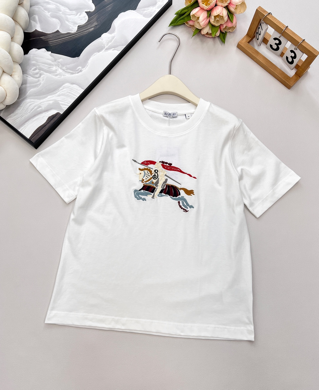 NO:454276,BURBERRY2025SS new round neck embroidered war horse short-sleeved T-shirt, customized YB native cotton material, breathable and comfortable, full texture, regular short-sleeved T-shirt cut, highlighting the brand style, made of gram-weight pure cotton, slightly elastic, giving a slimming visual effect, embroidered with colorful war horse logo pattern on the chest, the brand's own fashion sense is instantly created, creating a casual style at will, single wear and inner wear is brilliant and fashionable, customized surface accessories, three complete, two colors are available SML code, burberry, T-shirt,tees, t-shirt,alexander wang19860909BURBERRY2025SS新款圆领刺绣战马短袖T恤,定制YB原生全棉材质 透气舒适 质感十足 常规短袖T恤裁剪 凸显品牌格调 采用克重纯棉制成 略带有弹力 呈现显瘦视觉效果 胸前点缀刺绣彩色战马徽标图案 品牌自带的时尚感立现 随心打造休闲风格 单穿内搭都出彩时髦 定制面辅料 ,三标齐全,两色出 尺码sml 编码,,burberry,T-shirt,tees，t-shirt,alexander wang,Women's clothing