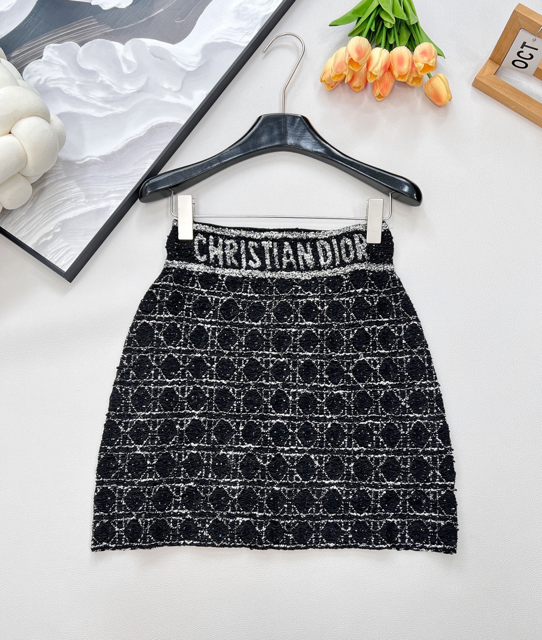 NO:736608,Dior cannage pattern heavy duty denim knitted jacket knitted skirt suit,  The classic cannage pattern of the cardigan is presented in the form of heavy-duty tweed. Every weaving embodies the hard work and ingenuity of the craftsmen. The delicate and three-dimensional texture not only gives the clothing a unique texture, but also demonstrates Dior's ultimate pursuit of quality.  The design of the lapel adds a bit of sophistication and elegance, appropriately modifying the neck line, showing women's femininity and confidence. Exquisite buttons are embellished on it, revealing luxury in simplicity, adding the finishing touch to the overall look. Every detail can withstand scrutiny.  The matching skirt is also full of highlights. The iconic cannage pattern on the skirt echoes with the cardigan, and the overall style is harmonious and unified. The high-waist design cleverly elongates the leg line, showing the graceful figure of a woman. It is worth mentioning that the eye-catching 'CHRISTIAN DIOR' words on the waist of the skirt are not only a symbol of the brand's identity, but also a declaration of fashion attitude. Walking on the street, it can easily become the focus of everyone's attention.  Whether worn separately or as a complete set, this suit can show a unique fashion charm. The cardigan can be paired with simple jeans to create a casual yet sophisticated daily look; the skirt can be combined with a solid-color shirt to create an elegant and intellectual workplace style. Of course, the complete set is even more aura. Whether it is attending a formal business occasion or a fashion party, it can be easily managed and show French luxury style. Complete with three standards, large quantities are available.  Size sml,,dior,skirts,jeans,jackets & coats,shirts,19860909Dior藤格纹重工粗花针织外套针织半裙套装, 开衫经典的藤格纹图案以重工粗花呢的形式呈现,每一处编织都凝聚着工匠们的心血与巧思.细腻而立体的纹理,不仅赋予了服装独特的质感,更彰显出Dior对于品质的极致追求.翻领的设计增添了几分干练与优雅,恰到好处地修饰颈部线条,展现出女性的柔美与自信.精致的纽扣点缀其上,简约中透露着奢华,为整体造型画龙点睛,每一个细节都经得起推敲. 搭配的半裙同样亮点十足.裙身上标志性的藤格纹与开衫相互呼应,整体风格和谐统一.高腰的设计巧妙地拉长腿部线条,展现出女性曼妙的身姿.值得一提的是,裙腰处醒目的“CHRISTIAN DIOR”字样,不仅是品牌身份的象征,更是时尚态度的宣言,走在街头,轻松成为众人瞩目的焦点. 这套套装无论是分开搭配还是成套穿着,都能展现出独特的时尚魅力.开衫可以搭配简约的牛仔裤,打造出随性又不失精致的日常造型；半裙则能与纯色衬衫组合,营造出优雅知性的职场风格.当然,成套穿着更是气场全开,无论是出席正式的商务场合,还是参加时尚派对,都能轻松驾驭,尽显法式奢华风情.三标齐全,大货出 尺码sml,,dior,skirts,jeans,jackets & coats,shirts,,Women's clothing