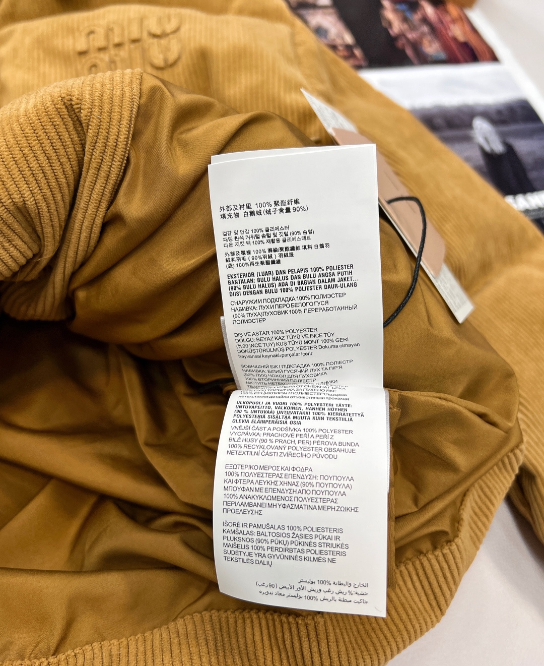 🆕 MIUMIU 暖色灯芯绒皮翻领拉链羽绒服，采用灯芯绒面料，手感柔软细腻，保暖性良好。同时，灯芯绒的表