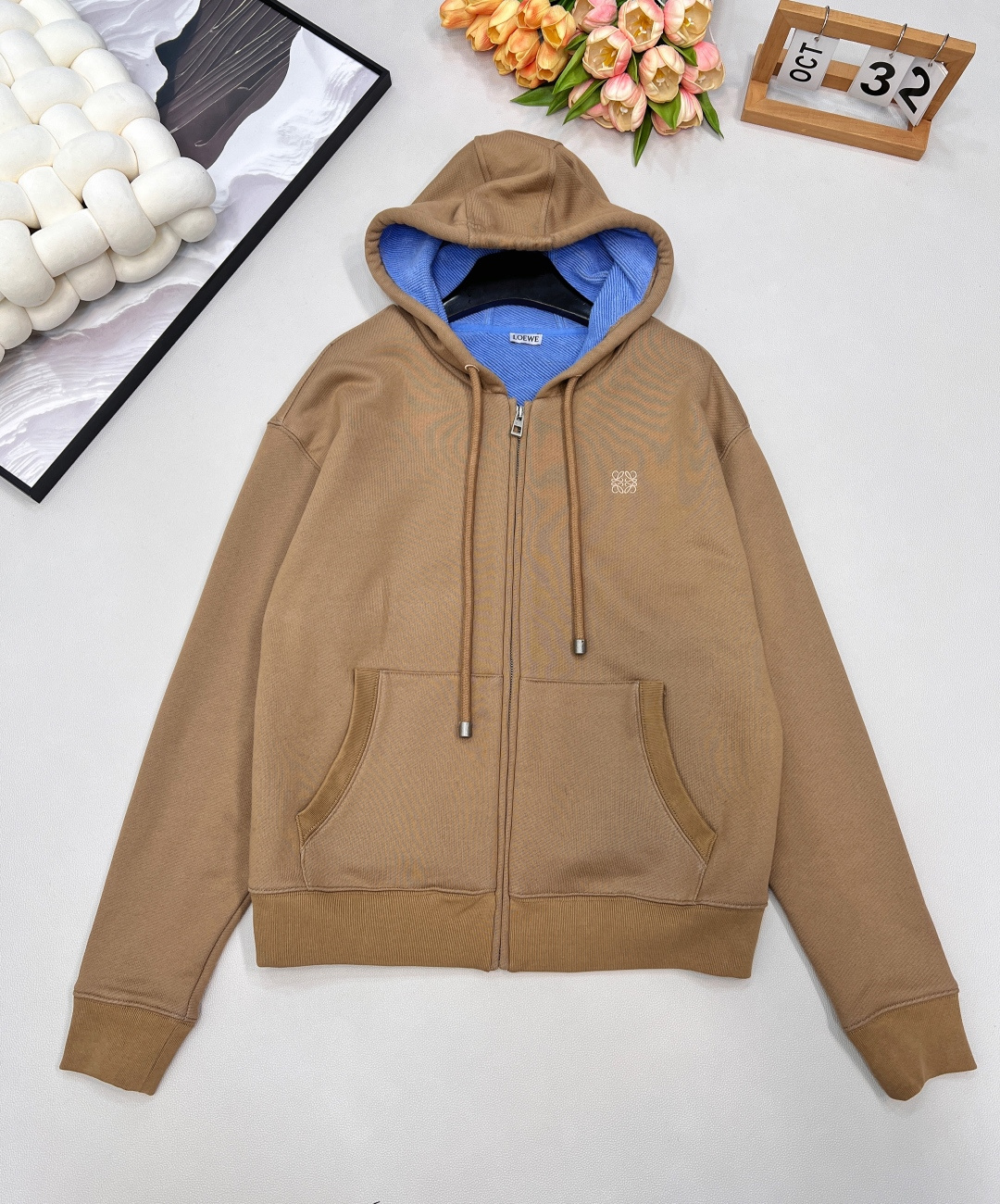 NO:565479,LOEWE embroidered hooded zipper sweatshirt jacket is the first atmospheric jacket in autumn and winter. It has a contrasting design of khaki and blue inside the hood, which makes the whole thing lively.  When warm khaki meets haze blue, a high-end color contrast game quietly begins. On the outside, it is LOEWE's iconic low-key texture, but on the inside, there is a deep ocean. The brim of the hat that is inadvertently turned up is a carefully designed style statement. The outline is outlined with exquisite embroidery, and the details are extraordinary.  Simple, not simple. The classic khaki sweatshirt jacket outlines the silhouette with extreme tailoring. The surprise lies in the detail of flipping the brim, jumping into a clear blue tone. The two-color interior and exterior create a modern style that is suitable for both movement and stillness.   Made of high-count combed cotton, it feels as soft and waxy as a cloud, but has a crisp silhouette on the upper body. The loose cut hides the body and is slimming, and is friendly to all body shapes. The iconic Anagram embroidered logo is low-key embellishment on the chest, and the full-length zipper design can be worn open to create a casual atmosphere. It can also be zipped up to turn into a casual hoodie in an instant, and the style can be switched freely. Easily wear it with effortless fashion. It has three standards, and is available in bulk. Size smlXL  coding,,loewe,hoodie,sweatshirts,jackets & coats,hats,alexander wang19860909LOEWE 刺绣连帽拉链卫衣外套 秋冬的第一件氛围感外套,卡其色和帽子内里蓝色撞色设计,整个就活泼起来了 当温润卡其邂逅雾霾蓝,一场关于高级的撞色游戏悄然开启.外在是LOEWE标志性的低调质感,内里却藏着一片深邃的海洋.不经意间翻起的帽檐,是精心设计的风格宣言.以精湛刺绣勾勒轮廓,于细节处彰显不凡 简约,不简单.经典卡其色卫衣外套,以极致剪裁勾勒廓形.惊喜在于细节翻转帽檐,跃入一片清澈蓝调.内外双色,演绎动静皆宜的摩登型格. 选用高支精梳棉打造,手感软糯如云朵,上身却带着挺括的廓形感,宽松剪裁藏肉显瘦,对各种身形都友好 标志性的Anagram刺绣徽标低调点缀胸前,全长拉链设计,可敞开穿营造随性氛围,也能拉上秒变休闲帽衫,风格切换自如.轻松穿出毫不费力的时髦感三标齐全,大货出 尺码smlXL 编码,,loewe,hoodie,sweatshirts,jackets & coats,hats,alexander wang,Women's clothing