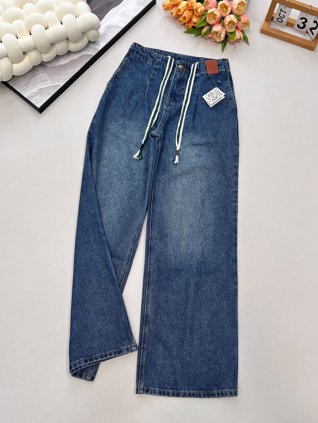 NO:565458,Loewe25Fw early autumn new drawstring high-waisted wide-leg denim trousers丨Exclusive high-end version!  It adopts a high-waisted wide-leg silhouette, and the trousers that hang naturally from the waistline modify the leg line like a waterfall, giving off a casual and lazy French sense of relaxation when walking; the unique white knotted drawstring at the waist, paired with the brand's iconic brown leather logo, cleverly combines the frankness of workwear style with the sophistication of a luxury brand. The tassel details at the end of the drawstring add a bit of fun and agility. Three standards are complete, and large quantities are available. Size sml  Coding L,,loewe,alexander wang19860909Loewe25Fw早秋新款抽绳高腰阔腿牛仔长裤丨独家高版出品！采用高腰阔腿廓形,从腰头自然垂坠的裤型如瀑布般修饰腿线,行走间尽释随性慵懒的法式松弛感；腰间别出心裁的白色绳结抽绳,搭配品牌标志性的棕色皮革徽标,将工装风的率性与奢牌的精致感巧妙糅合,抽绳末端的流苏细节更添几分灵动趣味,三标齐全,大货出 尺码sml 编码L,,loewe,alexander wang,Women's clothing
