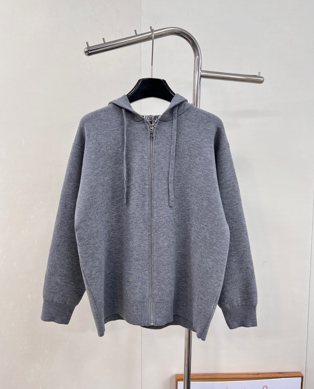 NO:569257,LOEWE's new back Anagram embossed zipper cardigan jacket. A secret sculpture, a high-end narrative when worn on the body. LOEWE's iconic embossed embossing technology quietly appears on the back of this cardigan. Fingertips stroke the surface of the fabric, and the concave and convex three-dimensional patterns are like hidden totems, only revealing a clue of identity to the outside world at the moment of turning around. Fluffy and soft, with a touch of high-grade gray as the base, it is the elegance tempered by time.  The front panel is decorated with a homogeneous clean fit display. The neat hooded design brings a touch of casualness and laziness. It is matched with the Anagram embossed embellishment on the back panel to inject the soul charm of the brand. The profound visual space shows an elegant figure and exudes infinite charm.   Double-sided stitching, drawstring hooded collar, original cuffs and hem, Anagram embossing on the back, and all hardware and accessories are originally developed!  A model of the intertwining of retro and fashion. It exudes a casual and lazy atmosphere, which can be seen every time you turn around. Every time you raise your hand, it shows your unique taste and extraordinary style, making the wearer the center of attention. Complete with three standards and two colors. Size sml code, loewe, loewe, jackets & coats, hats, alexander wang19860909LOEWE罗意威 新款后背Anagram压印拉链开衫外套 隐秘的雕塑,穿在身上的高级叙事 LOEWE标志性的浮雕压印工艺,在这件开衫的后背悄然登场.指尖抚过织物表面,凹凸的立体纹路如隐秘图腾,仅在转身瞬间向外界泄露一丝身份线索柔如云朵 蓬松又轻柔,以一抹,高级灰为底 是时光淬炼的优雅 前幅饰以同质化clean fit展示 利落的连帽设计 带着一丝随性与慵懒 搭配后幅Anagram 压纹点缀 注入品牌灵魂魅力 富有深意的视觉空间 尽显优雅身姿 散发无限魅力 双面缝线,抽绳连帽衣领,原声出袖口和下摆,背面饰有Anagram压纹,五金辅料全部原版开发！ 复古与时尚交织的典范 散发随性自在的慵懒气息,皆能在每一个转身 每一次抬手间,尽显独特品味与不凡格调,让穿着者成为目光焦点.三标齐全,两色出 尺码sml 编码,,loewe,loewe,jackets & coats,hats,alexander wang,Women's clothing