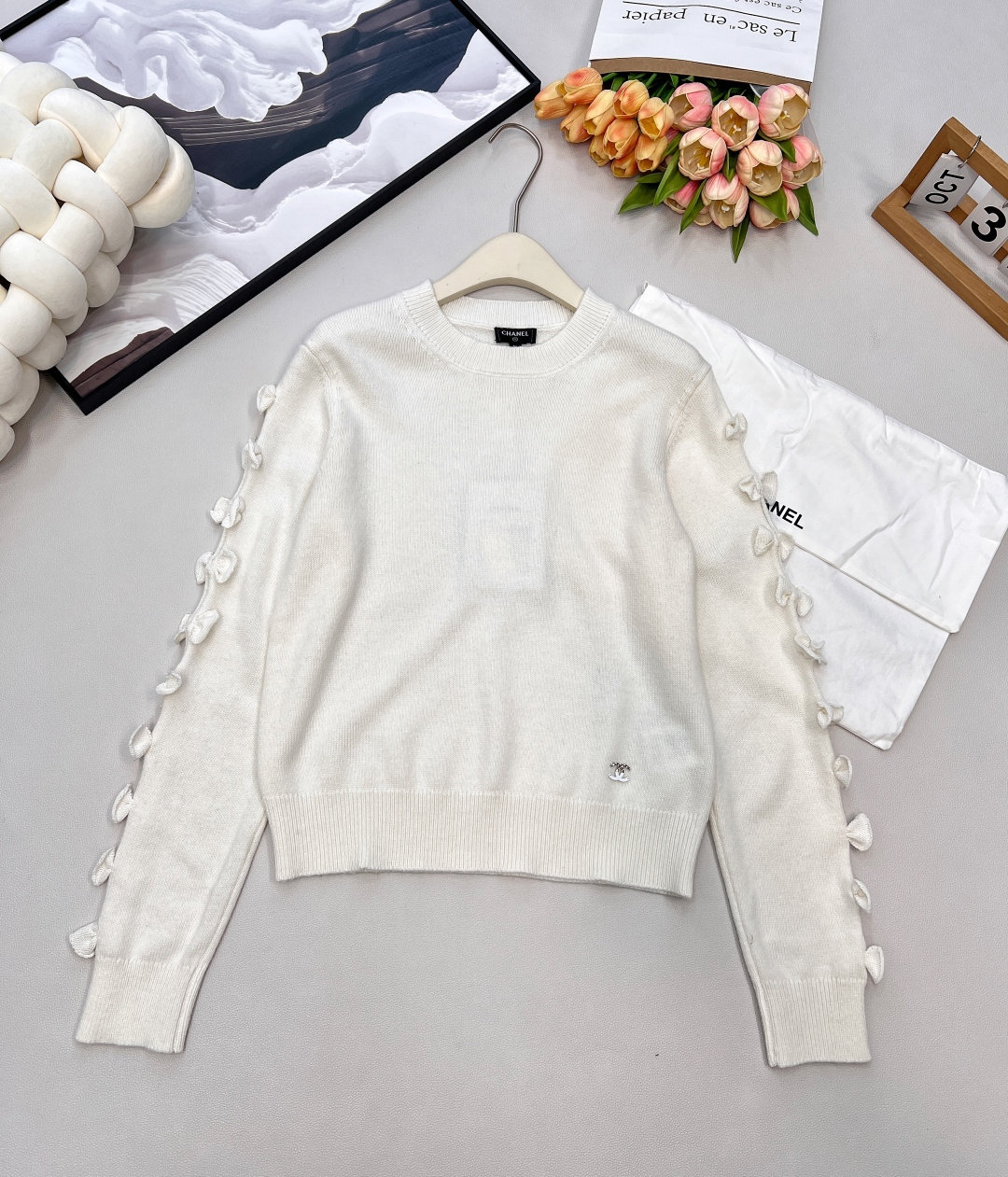 NO:570262,Chanel2025 new sleeve bow knitted top, custom YB cashmere yarn weaving, texture and luster, soft and skin-friendly, long-sleeved knitted top version, loose texture without losing fashion sense, collar extends to the front, contrasting color binding, elastic threaded stripe binding, hollow three-dimensional bow decoration on the outside of the sleeves, round double C letter logo decoration, showing a playful age-reducing style, big color matching and elegant temperament, the first choice for daily wear, customized surface accessories, look for the version  Complete three standards, two colors, size sml code, chanel, alexander wang19860909Chanel2025新款袖子蝴蝶结针织上衣,定制YB羊绒纱线织造 质感光泽 柔软亲肤 长袖针织上衣版型 肌理松弛不失时尚感 领边延伸至前襟撞色包边 通体弹力螺纹条纹包边 袖子外侧镂空立体蝴蝶结装饰 圆配合双C字母徽标装饰 展现俏皮减龄风格 大身配色气质大方 日常穿搭首选 定制面辅料,认准版本 三标齐全,两色出 尺码sml 编码,,chanel,alexander wang,Women's clothing