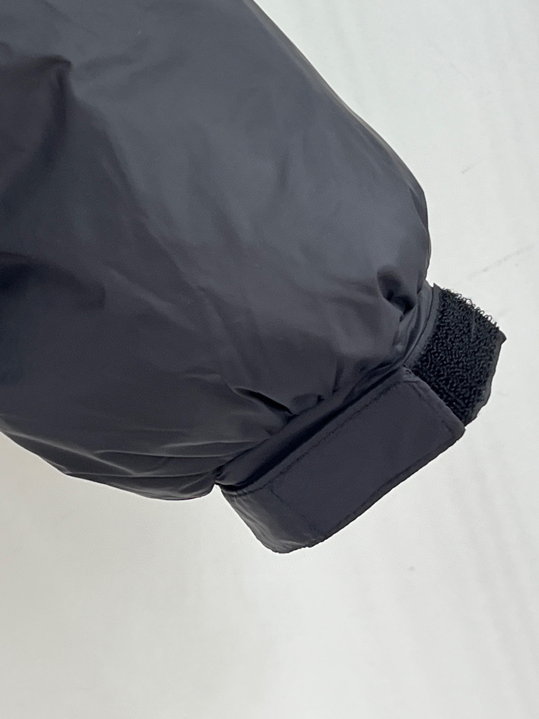 🆕PRAD25FW秋冬三角标连帽羽绒服外套，抽绳末端的金属扣为品牌定制款，质感细腻且经久耐用。门襟选用双