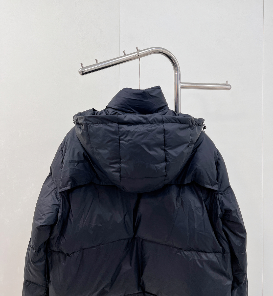 🆕PRAD25FW秋冬三角标连帽羽绒服外套，抽绳末端的金属扣为品牌定制款，质感细腻且经久耐用。门襟选用双