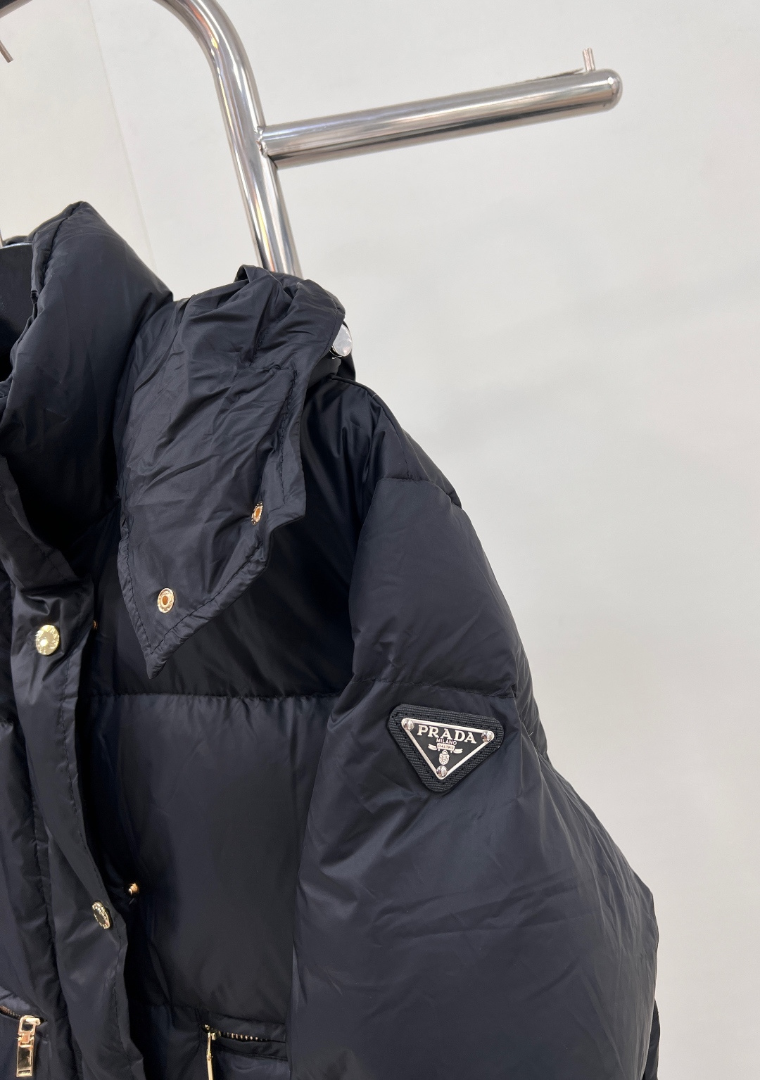 🆕PRAD25FW秋冬三角标连帽羽绒服外套，抽绳末端的金属扣为品牌定制款，质感细腻且经久耐用。门襟选用双