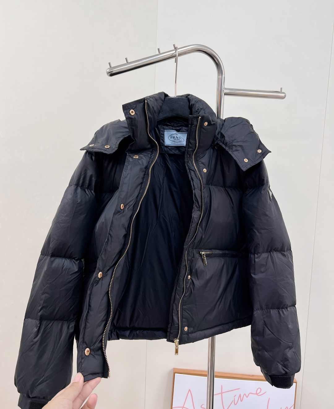 🆕PRAD25FW秋冬三角标连帽羽绒服外套，抽绳末端的金属扣为品牌定制款，质感细腻且经久耐用。门襟选用双