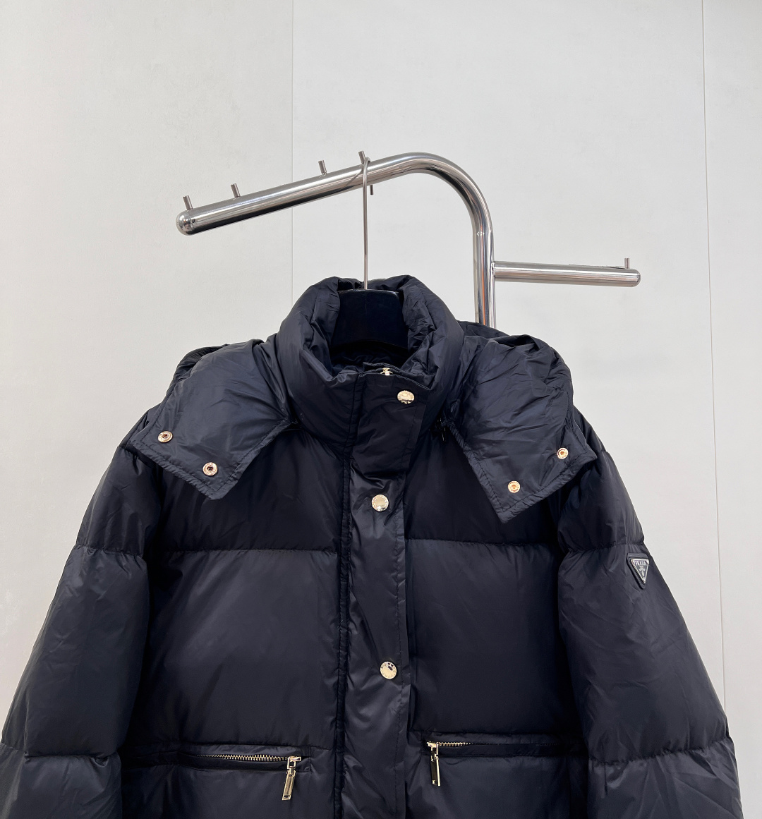 🆕PRAD25FW秋冬三角标连帽羽绒服外套，抽绳末端的金属扣为品牌定制款，质感细腻且经久耐用。门襟选用双