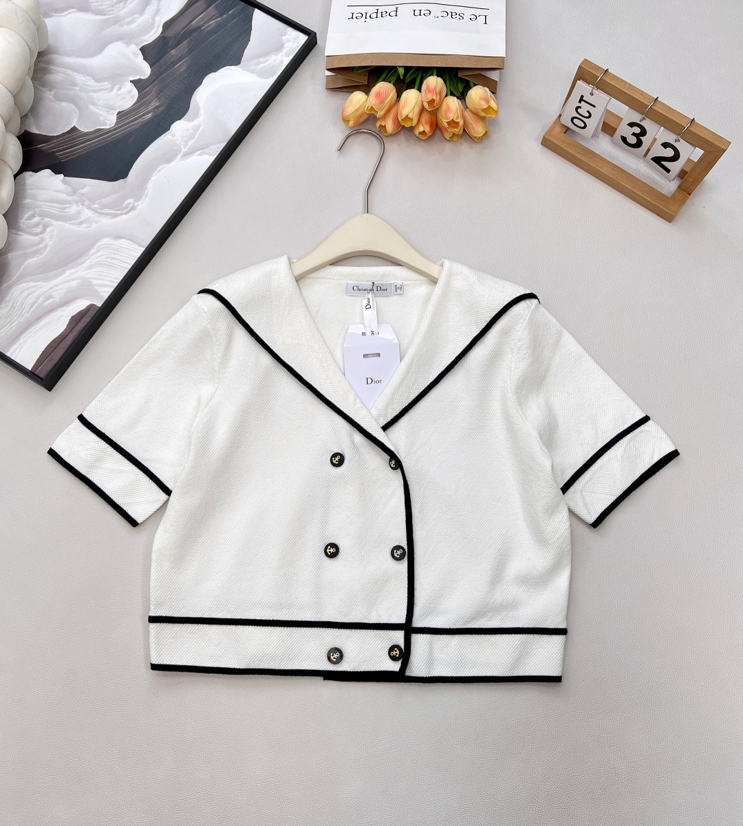 NO:590107,DIOR's new navy collar contrasting color knitted short jacket is a perfect collision of French elegance and modern spontaneity. When the classic navy collar meets Dior's high-end fashion genes, this short jacket is destined to become the focus of the wardrobe. Pure off-white knitting interweaves delicate textures, and black contrast binding outlines neat lines. The navy collar design has a retro style, and the short-sleeved cut and short version are full of modernity.  The double-row metal buttons are exquisitely embellished, each one engraved with Dior's ingenuity, and the opening and closing express an elegant tone. Whether it is paired with high-waisted jeans to create a casual French style, or combined with a skirt of the same series and a suit of the same color, you can easily create a high-end look. Three standards are complete, and large quantities are shipped. Size sml code D,, dior, dior, skirts, jeans, jackets & coats, T-shirt, alexander wang19860909DIOR新款海军领撞色针织短夹克,法式优雅与摩登率性的完美碰撞,当经典海军领邂逅迪奥的高级时尚基因,这款短夹克注定成为衣橱焦点.纯净米白针织交织细腻纹理,黑色撞色包边勾勒出利落线条,海军领设计自带复古风情,又因短袖剪裁与短款版型注入满满摩登感. 双排金属扣精致点缀,每一颗都镌刻着迪奥的匠心,开合间尽释优雅腔调.无论是搭配高腰牛仔裤打造随性法式风,还是与同系列半裙组合同色系套装,都能轻松拿捏高级感穿搭.三标齐全,大货出 尺码sml 编码D,,dior,dior,skirts,jeans,jackets & coats,T-shirt,alexander wang,Women's clothing