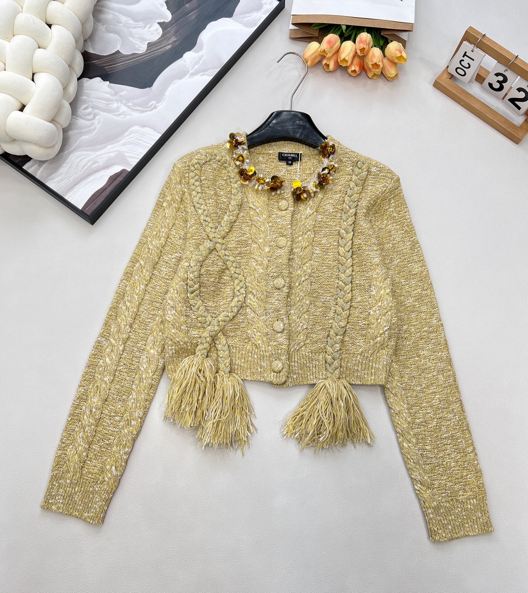 NO:590094,CHANEL's new beaded knitted cardigan with a small fragrant style collar is a popular 'old money style' dressing item. It uses retro cable knitting technology, and the overall color is light gold, with a delicate and layered texture. The hand-made beading design at the neckline is the highlight, which combines flowers and sequins elements, giving it a luxurious yet sophisticated feel; the tassel decoration on the hem adds a lively atmosphere, making the overall style a bit playful and elegant.  The style is very suitable for creating a 'golden style' look. It can be paired with a high-waisted skirt or jeans on a daily basis, and it can be easily worn with a light luxury retro high-end feel. The three standards are complete, and the goods are shipped in large quantities. Sizes sml code, chanel, skirts, jeans, alexander wang19860909CHANEL新款小香风领口穿珠针织开衫,当下流行的“老钱风”穿搭单品.它采用了复古绞花针织工艺,整体为浅金色调,质感精致且富有层次感.领口处的手工穿珠设计是亮点,融合了花朵与亮片元素,奢华又不失精致感；下摆的流苏装饰则增添了灵动气息,让整体风格在优雅中带点俏皮. 款式很适合打造“千金风”造型,日常可以搭配高腰半裙或牛仔裤,轻松穿出轻奢复古的高级感,三标齐全,大货出 尺码sml 编码,,chanel,skirts,jeans,alexander wang,Women's clothing
