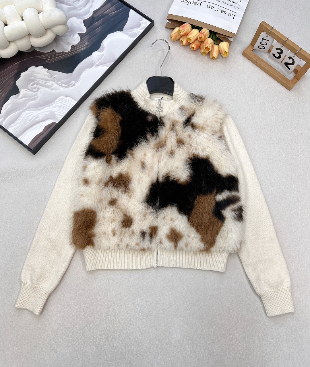 NO:591069,CELINE's new furry all-in-one knitted cardigan is a luxurious collision of fur and knitting. The logo on the back hides identity recognition. The front is knitted with mottled fur. The contrasting colors of brown, black and off-white are like artistic blooming. The brand metal logo on the zipper adds exquisite details; when you turn around, the letter logo on the back quietly  The brand recognition is clearly revealed, and the brand recognition is hidden in the ingenuity of dressing. The warmth of knitting and the luxury of fur are intertwined, allowing it to play a personal role in street style, and also play a supporting role in elegant outfits. It can easily adapt to a variety of styles and is an 'eye-catching weapon' that will make you stand out from the crowd this winter. Complete with three standards, large quantities are shipped.  Size sml code E7,,celine,alexander wang19860909CELINE新款毛毛一体针织开衫,皮毛与针织的奢感碰撞,后背徽标暗藏身份辨识度,正面以斑驳皮毛拼接针织,棕、黑、米白的撞色如同艺术晕染,拉链处的品牌金属徽标更添精致细节；转身间,后背的字母logo徽标悄然显露,将品牌辨识度藏于穿搭巧思中.针织的温润与皮毛的奢感交织,让它既能在街头风里做个性担当,又能在优雅系穿搭中当质感配角,轻松适配多种风格,是这个冬天让你从人群中脱颖而出的“吸睛利器”.三标齐全,大货出 尺码sml 编码E7,,celine,alexander wang,Women's clothing