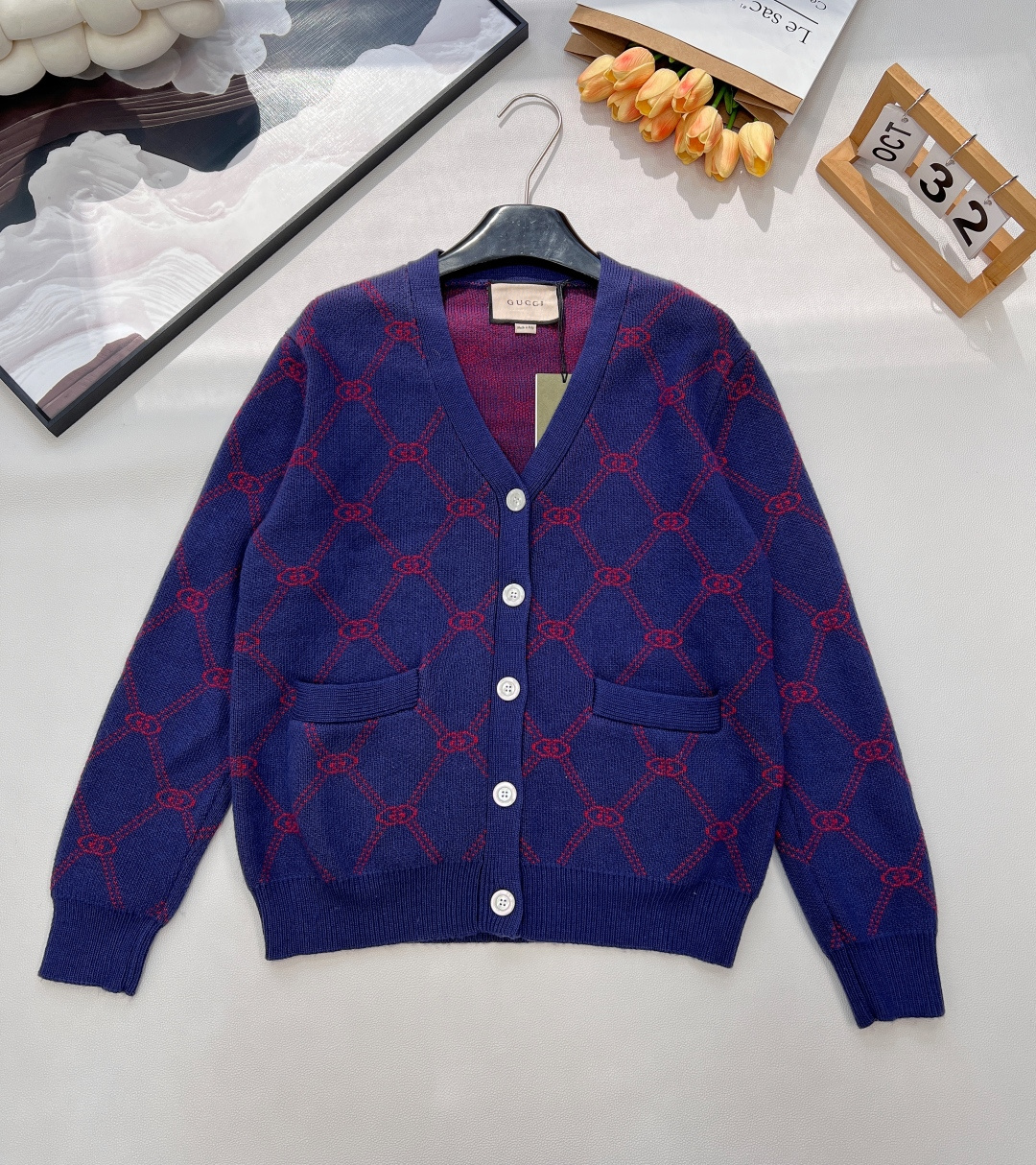 NO:591046,Gucci's 2025 new double-G diamond pattern knitted V-neck cardigan is the perfect fusion of retro texture and luxury brand recognition. Navy blue background meets burgundy jacquard. Gucci's 2025 new V-neck cardigan directly brings 'retro luxury' and 'brand recognition' to the fullest!  The classic double G diamond pattern covers the body, and the calmness of navy meets the enthusiasm of burgundy. The retro charm instantly bursts out, and every gesture is full of texture. The upper body of the soft and waxy knitted fabric is soft and comfortable, as if it is wearing gentleness on the body, and the comfort of daily wear is directly enhanced. The V-neck cut modifies the shoulder and neck lines, and the five pearl white buttons are exquisite and grand. The hem patch pockets are both practical and stylish, casual and yet stylish.  From the jacquard details to the brand logo, Gucci's ingenuity is hidden in every corner, allowing you to switch freely between retro and modern. Whether paired with jeans for a casual and trendy style, or paired with a skirt for an elegant retro style, this cardigan can be the finishing touch of the style, easily wearing the luxury brand's exclusive high-end feel~ Complete with three standards, large quantities available. Sizes sml code G,, gucci, skirts, jeans, alexander wang19860909Gucci 2025新款双G菱格纹针织V领开衫,复古质感与奢牌辨识度的完美融合,藏青底色邂逅酒红提花,Gucci这款2025新款V领开衫,直接将“复古高级感”和“品牌辨识度”拉满！ 经典双G菱格纹铺满衣身,藏青的沉稳撞上酒红的热烈,复古韵味瞬间迸发,举手投足间尽是质感腔调；软糯针织面料上身柔软舒适,仿佛把温柔穿在身上,日常穿搭的舒适感直接拉满.V领剪裁修饰肩颈线条,五颗珍珠白纽扣精致又大气,下摆贴袋兼顾实用与造型感,随性又不失格调. 从提花细节到品牌标识,每一处都藏着Gucci的匠心巧思,让你在复古与现代之间自如切换,无论是搭配牛仔裤打造随性潮范,还是搭配半裙演绎优雅复古风,这款开衫都能成为造型的点睛之笔,轻松穿出奢牌专属的高级感~三标齐全,大货出 尺码sml 编码G,,gucci,skirts,jeans,alexander wang,Women's clothing