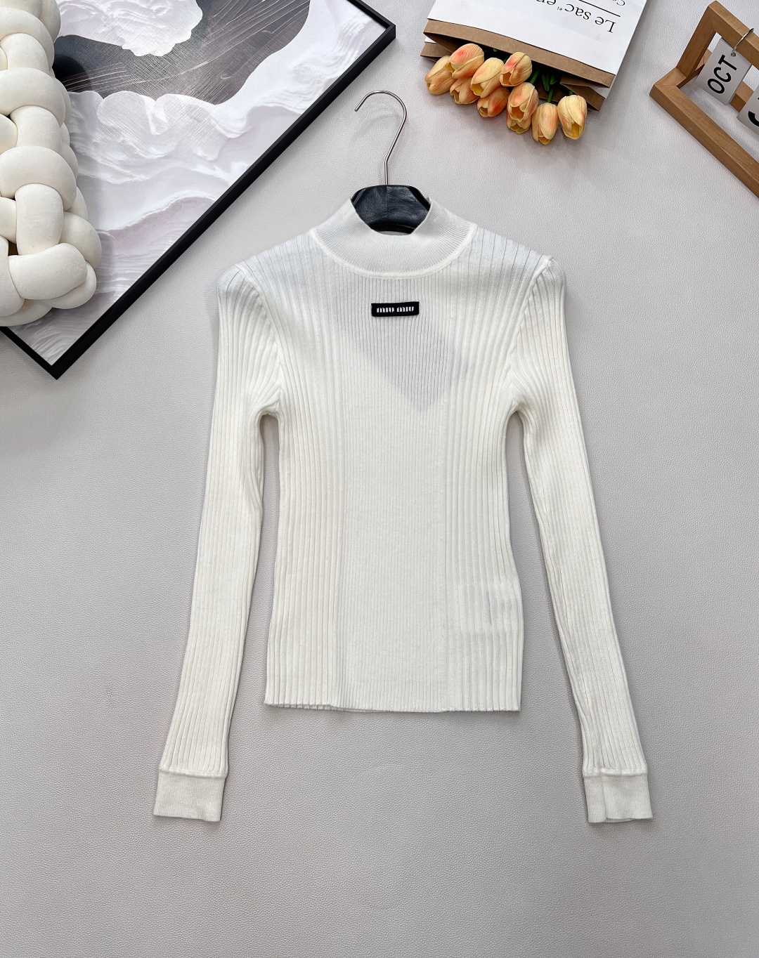 NO:591557,Miumiu25FW new autumn and winter micro-label jacquard goat wool blend stand-collar knitted long-sleeved bottoming shirt丨Exclusive high-end version!  Made of wool knitted fabric, it has a soft and waxy touch like clouds, and is delicate and skin-friendly without being stuck; it is embellished with letter jacquard micro-marks on the chest, and is slim-fitting and slightly elastic. It fits the body shape but is not tight, and is compatible with various body shapes; the classic basic model with stand-up collar + long sleeves is a practical model that 'goes with everything' in the autumn and winter wardrobe. Complete with three standards, large quantities are shipped. Size smL code M,, miumiu, alexander wang19860909Miumiu25FW秋冬新款微标提花山羊毛混纺立领针织长袖打底衫丨独家高版出品！采用羊毛针织面料,自带云朵般软糯触感,细腻亲肤不扎身；胸前点缀字母提花微标,修身微弹剪裁,贴合身形却不紧绷,兼容各种身型；立领+长袖的经典基础款型,是秋冬衣橱里「万物皆可搭」的实用款.三标齐全,大货出 尺码smL 编码M,,miumiu,alexander wang,Women's clothing