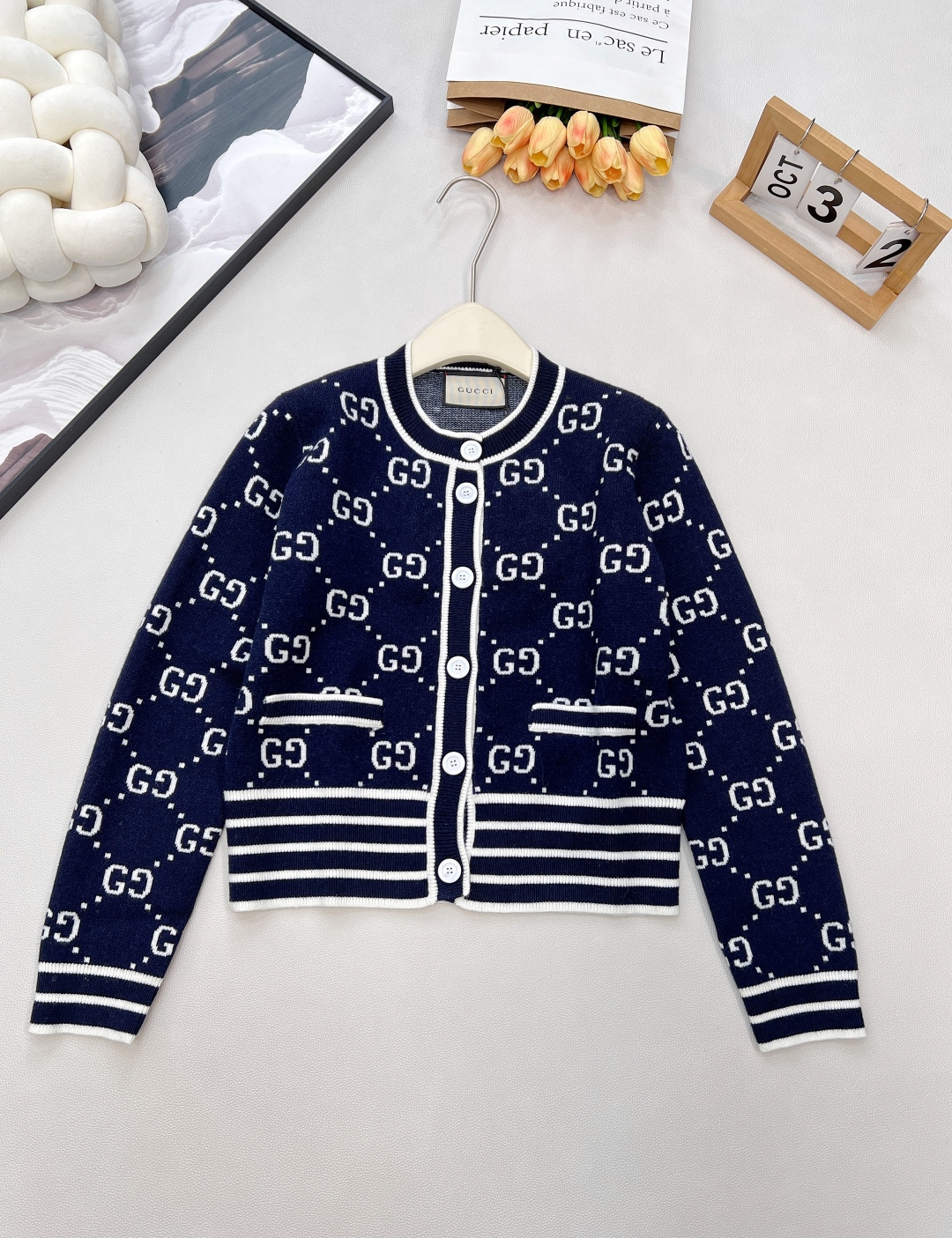 NO:797662,GUCCI's new double G long-sleeved cardigan in contrasting colors is interlaced with blue and white diamonds. When GUCCI's classic double G meets custom-dyed blue and white yarn, this long-sleeved cardigan becomes the 'key to luxury and elegance' for spring wear. The full GG diamond pattern is carefully woven with exclusive yarn, and every texture reveals a high-end texture. The blue and white contrasting colors are classic and elegant, and are a vivid expression of the brand's century-old fashion gene.  The classic round neck style is versatile and easy to match. The contrasting thread workmanship is delicately displayed on the collar, cuffs and hem to outline a neat silhouette. The original customized logo buttons are arranged in sequence, and every opening and closing is a silent expression of the brand's style. The short cut is suitable for various body shapes.  It can be worn with a shirt or suspenders, and when worn alone, it combines retro and modern styles. In spring, it is the finishing touch to create a layered look, allowing you to easily wear a high-end atmosphere unique to GUCCI between elegance and coolness. Complete with three standards, large quantities are available.  Size sml code G,,gucci,shirts,19860909GUCCI新款双G撞色长袖开衫,蓝白菱格交织,当GUCCI经典双G邂逅定染蓝白纱线,这件长袖开衫便成了春日穿搭的“奢雅密钥”.满幅GG菱格肌理由专属纱线精心织就,每一处纹理都透着高级质感,蓝白撞色经典大气,是品牌百年时尚基因的鲜活表达. 经典圆领版型百搭不挑人,撞色螺纹工艺在领口、袖口与下摆细腻呈现,勾勒利落轮廓；原版定制logo扣依次排列,每一次开合都是品牌格调的无声彰显.短款剪裁适配各种身形,内搭衬衫、吊带皆可,单穿更是将复古与摩登一网打尽.春日里,它是打造层次造型的点睛之笔,让你在优雅与潮酷之间,轻松穿出独属于GUCCI的高级氛围感.三标齐全,大货出 尺码sml 编码G,,gucci,shirts,,Women's clothing